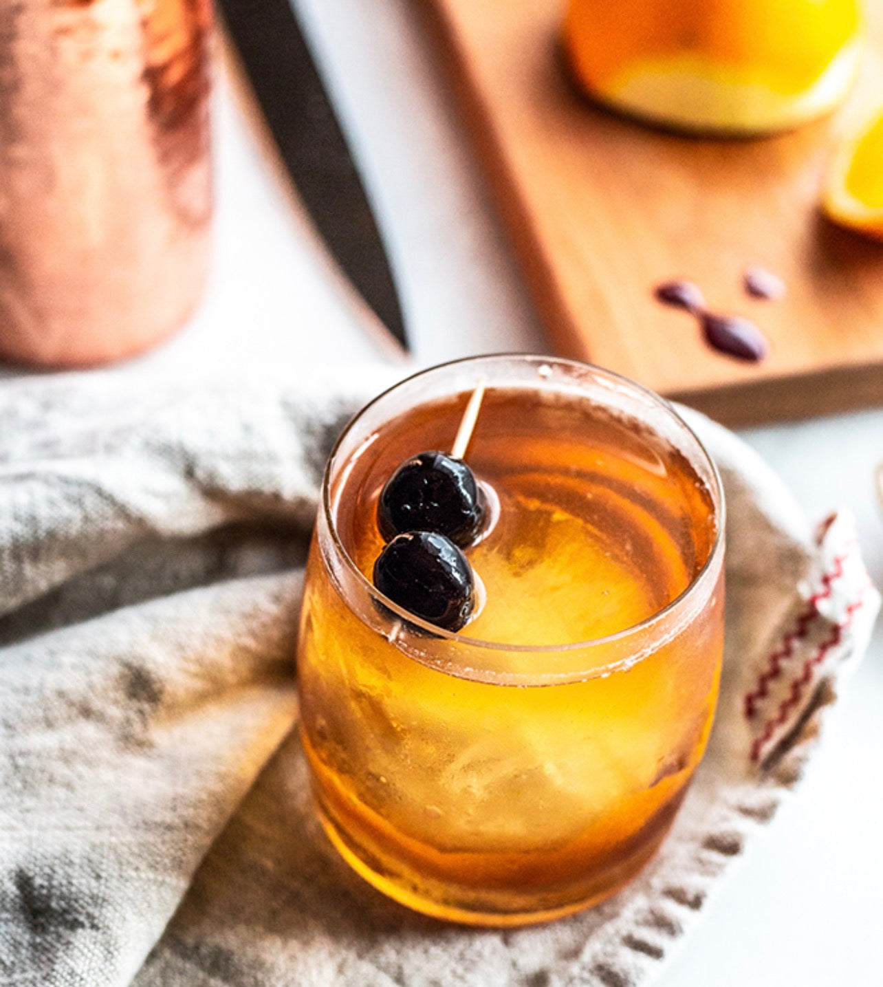 Old fashioned cocktail garnished with cherries