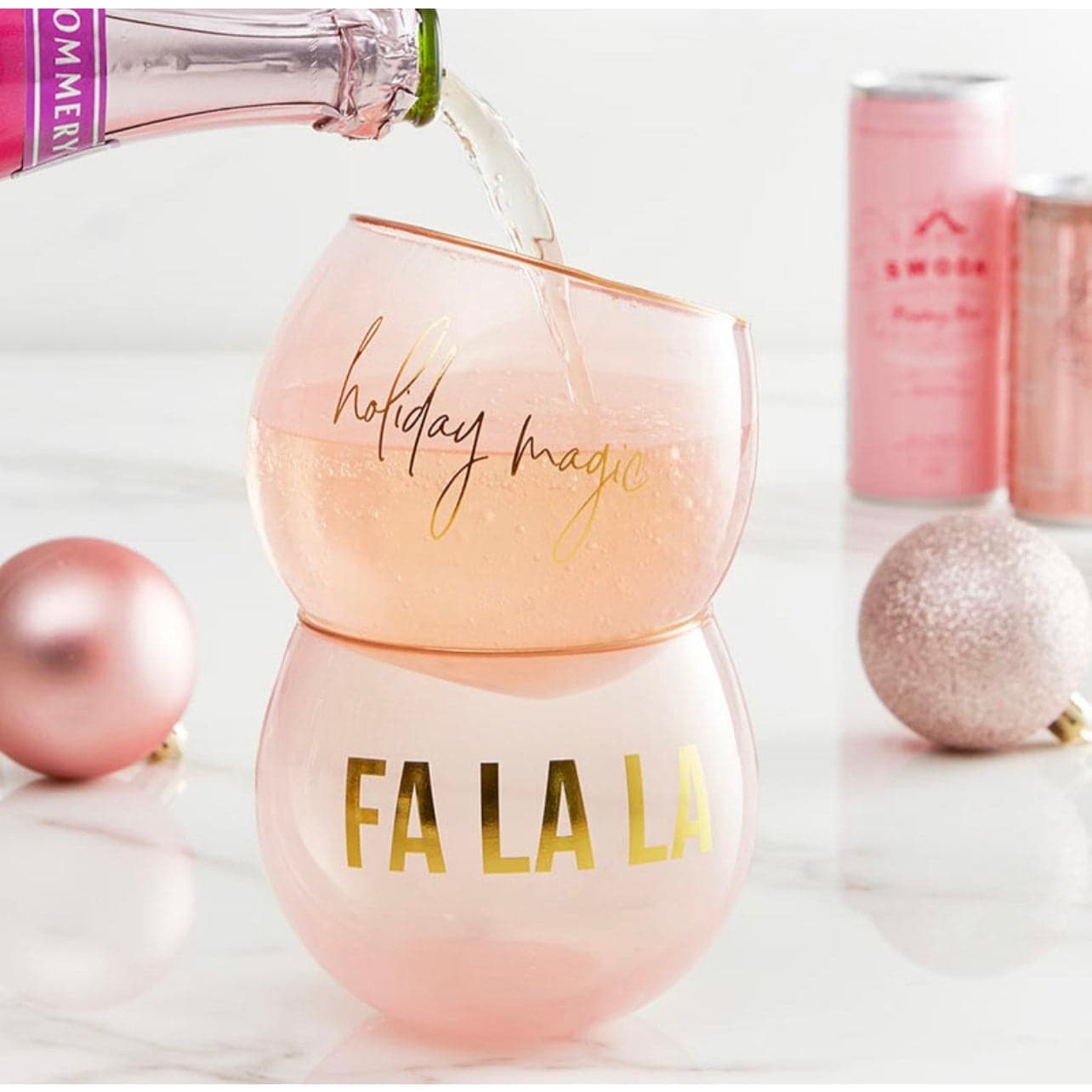 display of a set of blush colored holiday cocktail glasses with sparkling wine being poured in them