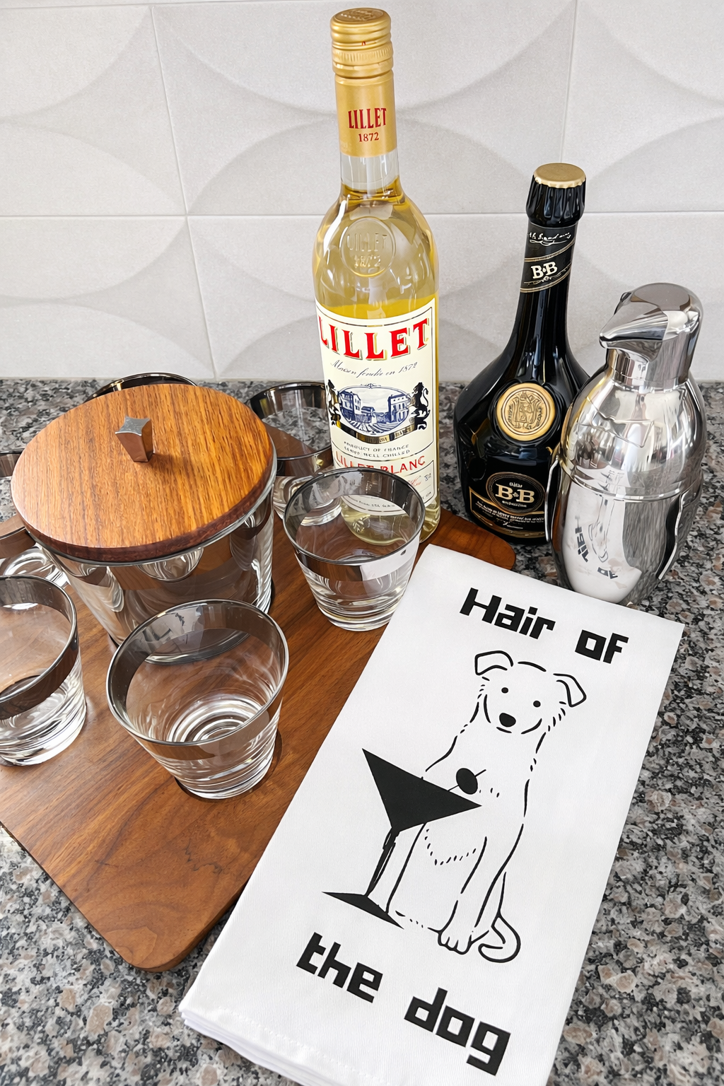 Hair of the Dog dog cocktail tea towel styled with glassware and bar tools