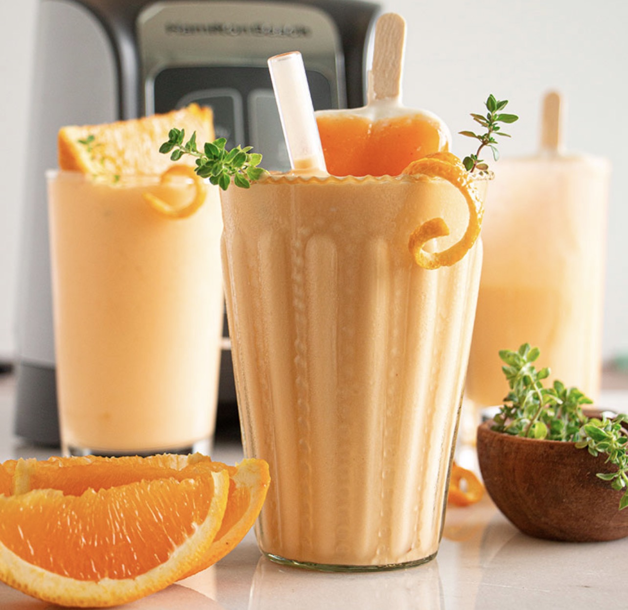 Frozen orange creamsicle cocktail in glass with orange garnish made with Noble Mick’s cocktail mix