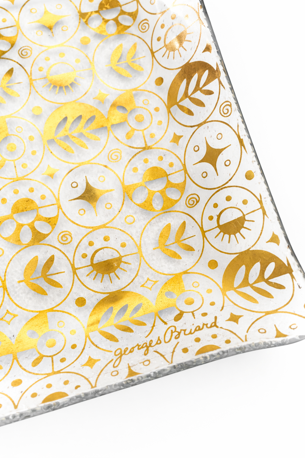 Close-up of signed Georges Briard 22K gold atomic pattern on vintage glass serving tray