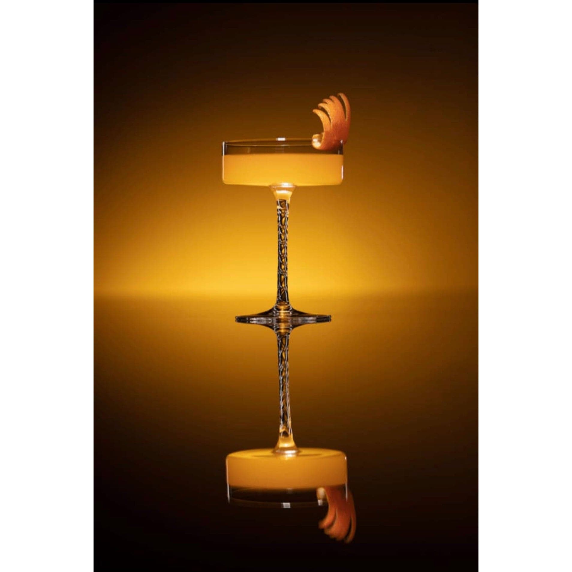 Sidecar cocktail in a martini glass garnished with orange