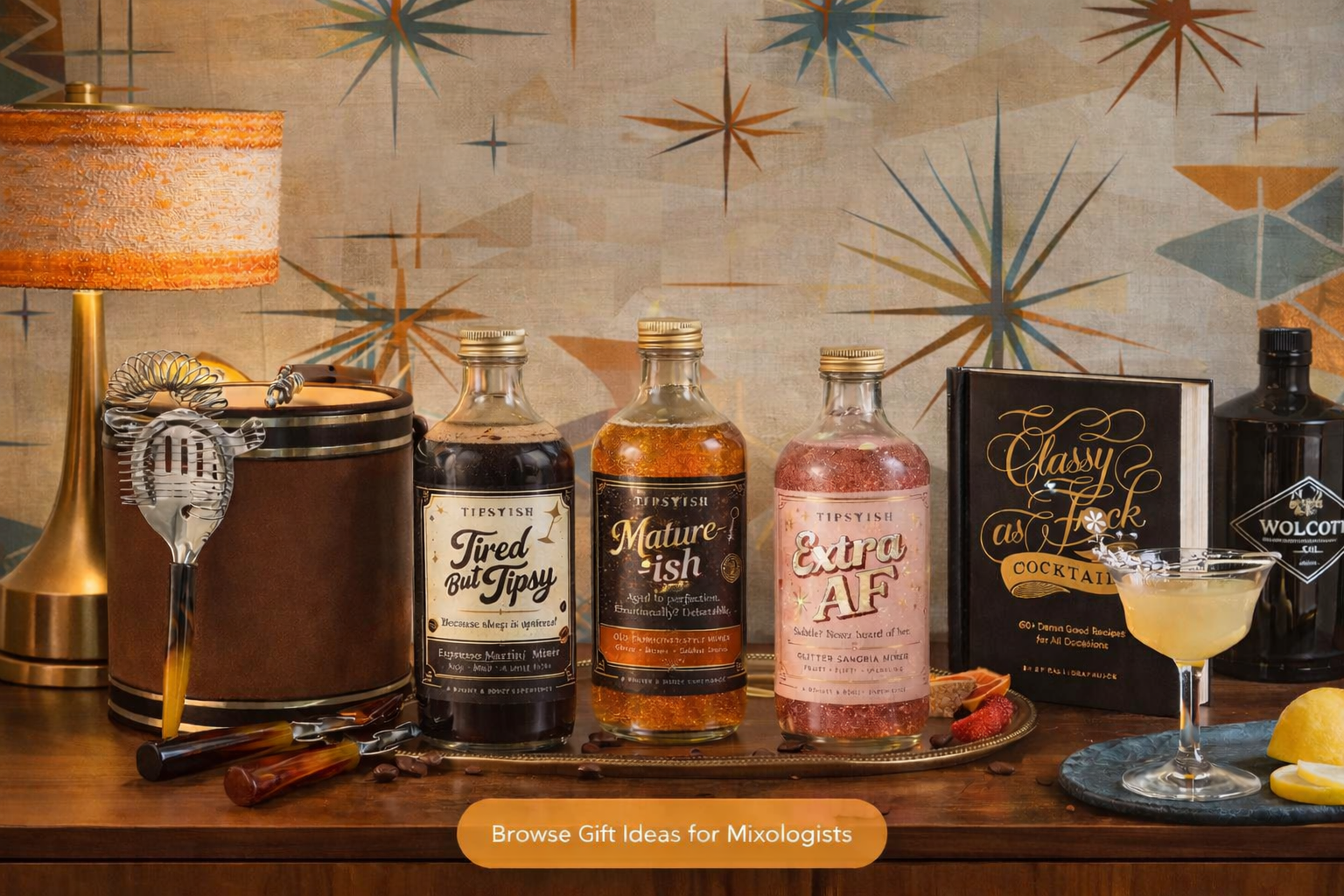 Midcentury modern home bar scene featuring vintage leather ice bucket with tortoiseshell bar tools, Tipsyish cocktail mixers, cocktail recipe book, and classic martini styled as curated gifts for cocktail lovers.