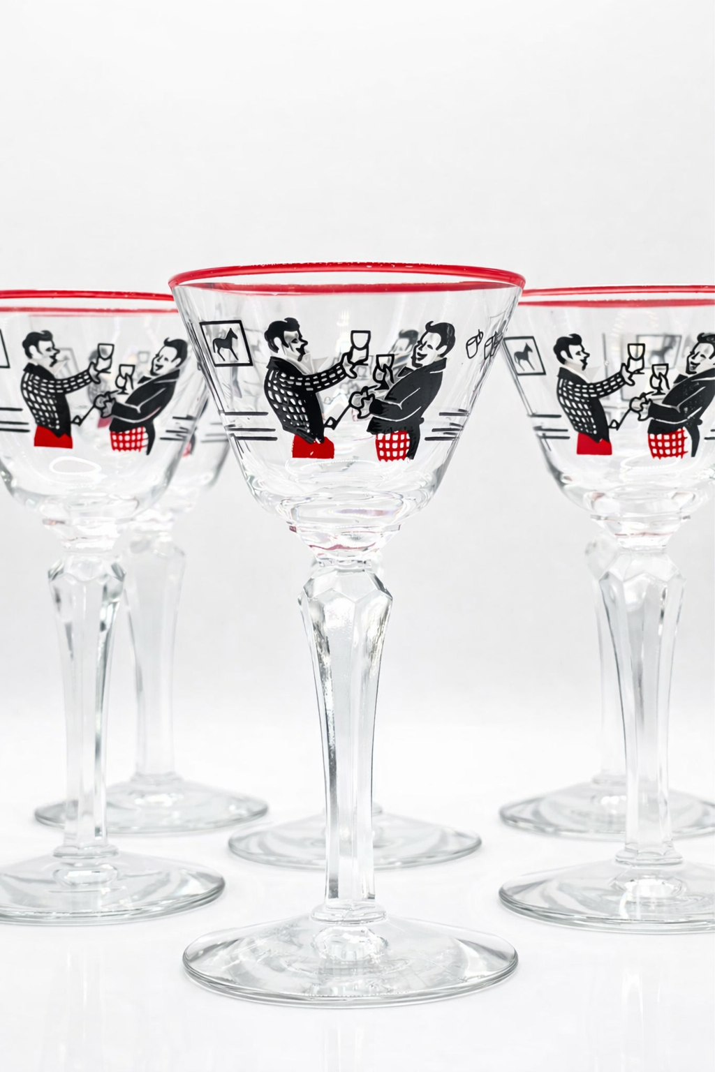 Set of clear cocktail glasses with red rims and black illustrations on a white background