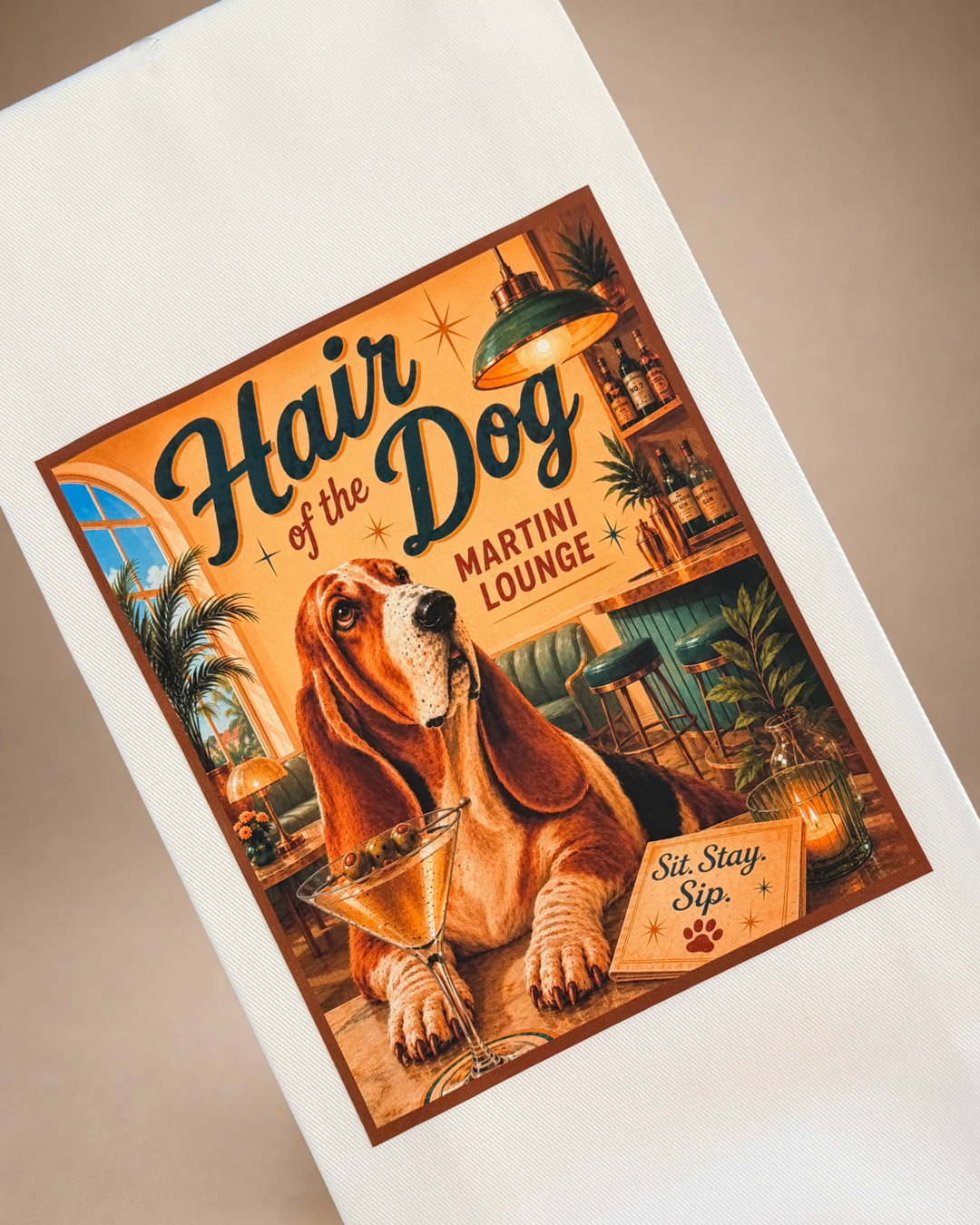 Close-up of vintage-inspired Hair of the Dog Martini Lounge tea towel featuring a Basset Hound and olive martini.