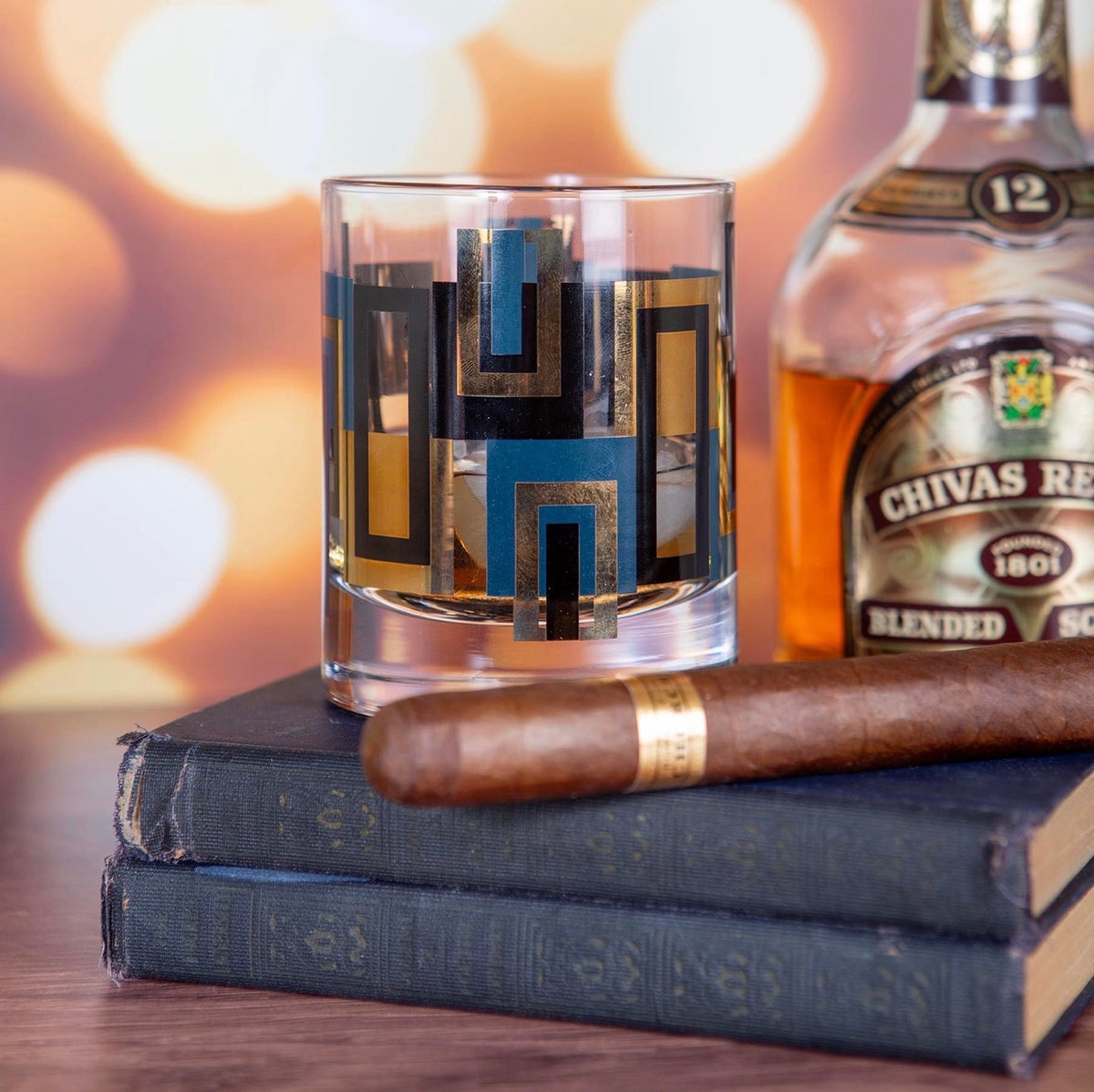 Mid century modern blue and metallic gold whiskey glass styled with bourbon and vintage-inspired cocktail accessories