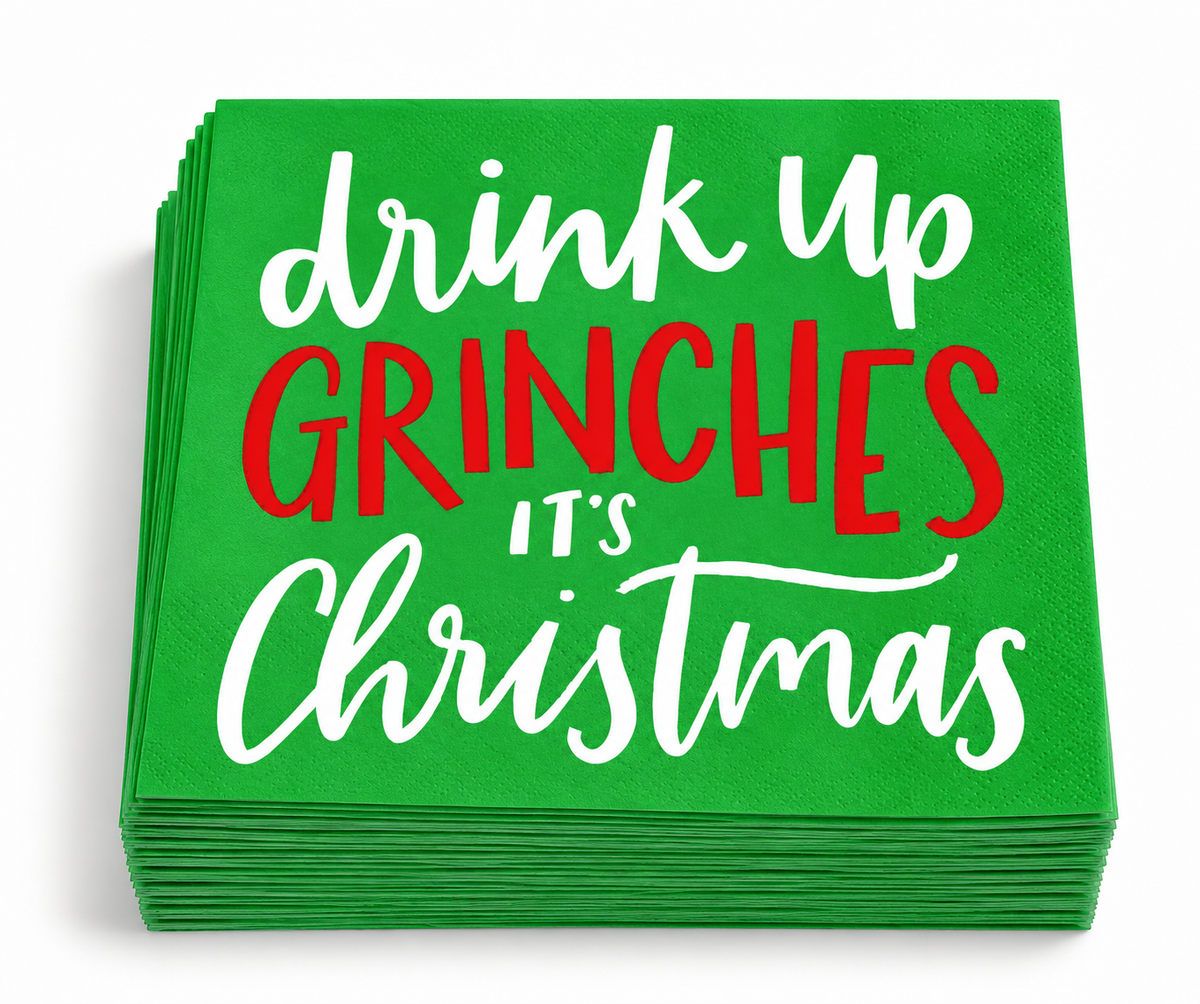 Stack of green Drink Up Grinches Christmas cocktail napkins showing the festive red and white design.