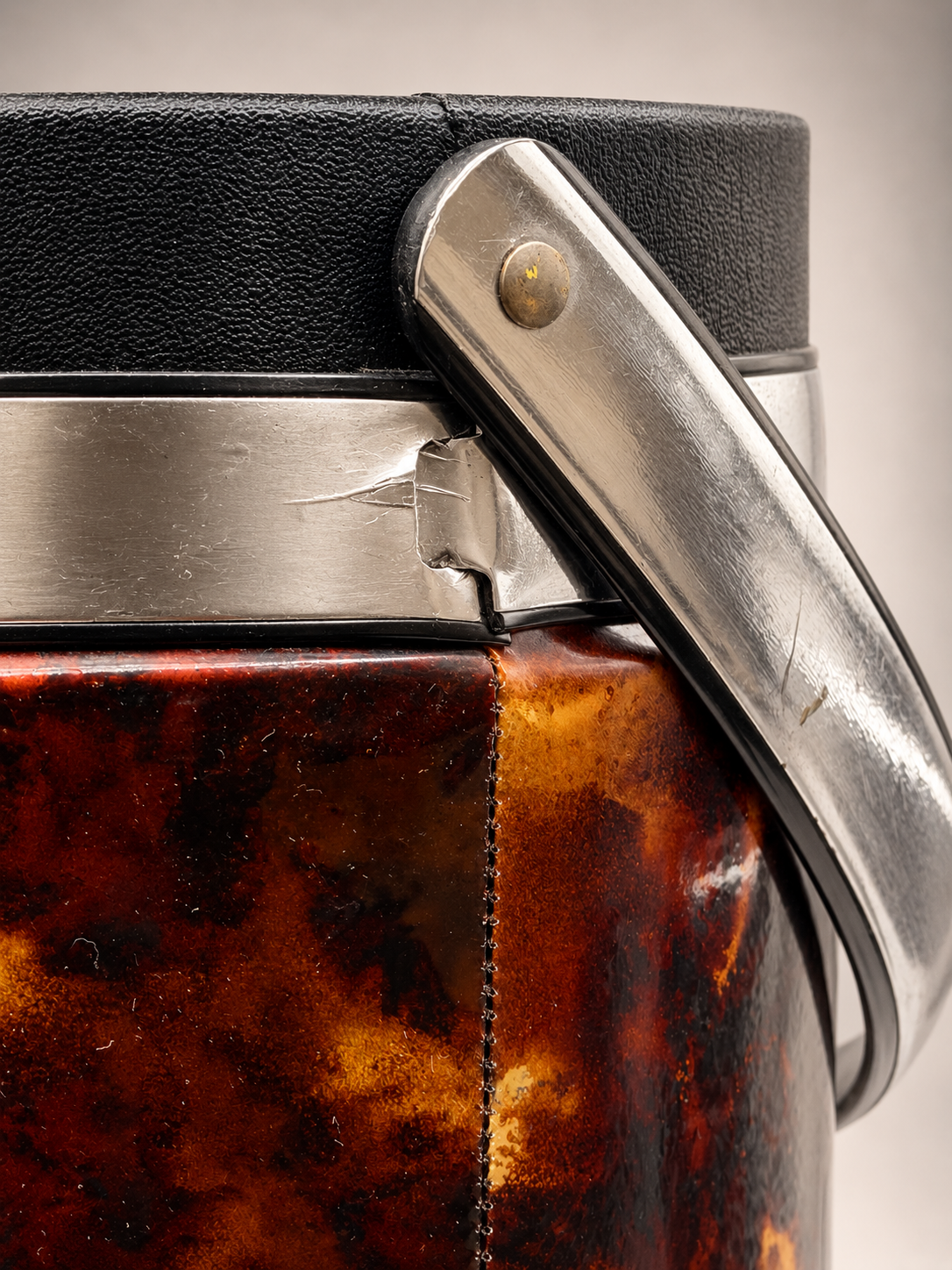 Close-up of vintage Elmar ice bucket showing silver-tone handle attachment, scratches, and age-related wear near the metal band.