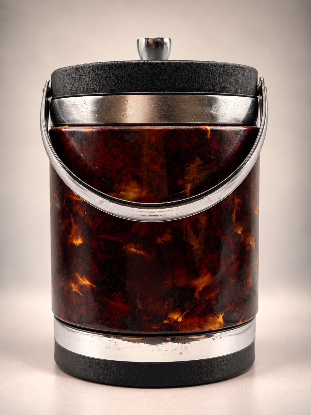 Rear view of vintage Elmar faux tortoiseshell ice bucket with curved silver-tone handle and black textured trim.