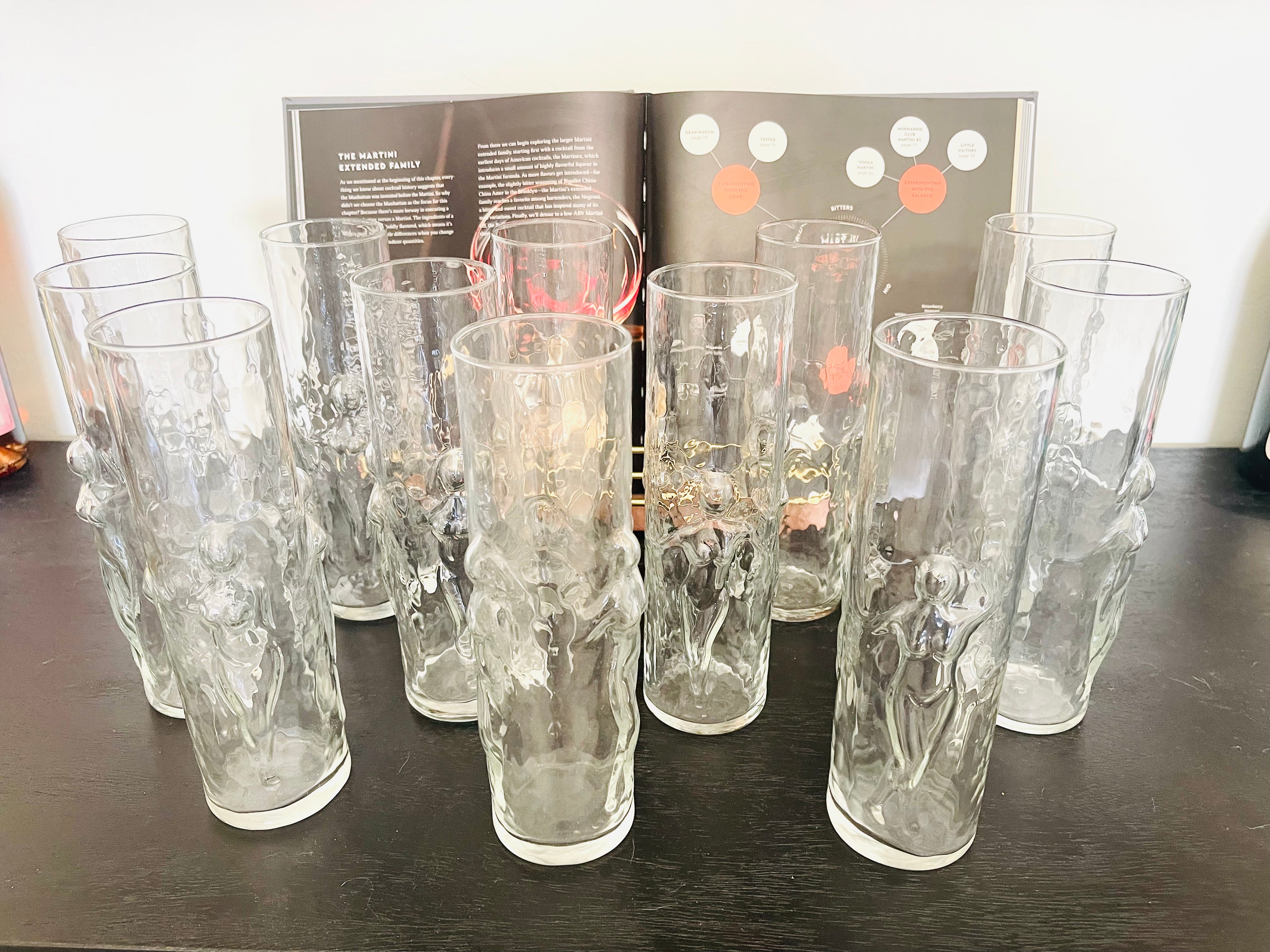 Set of etched glass tumblers on a dark surface with a magazine in the background.