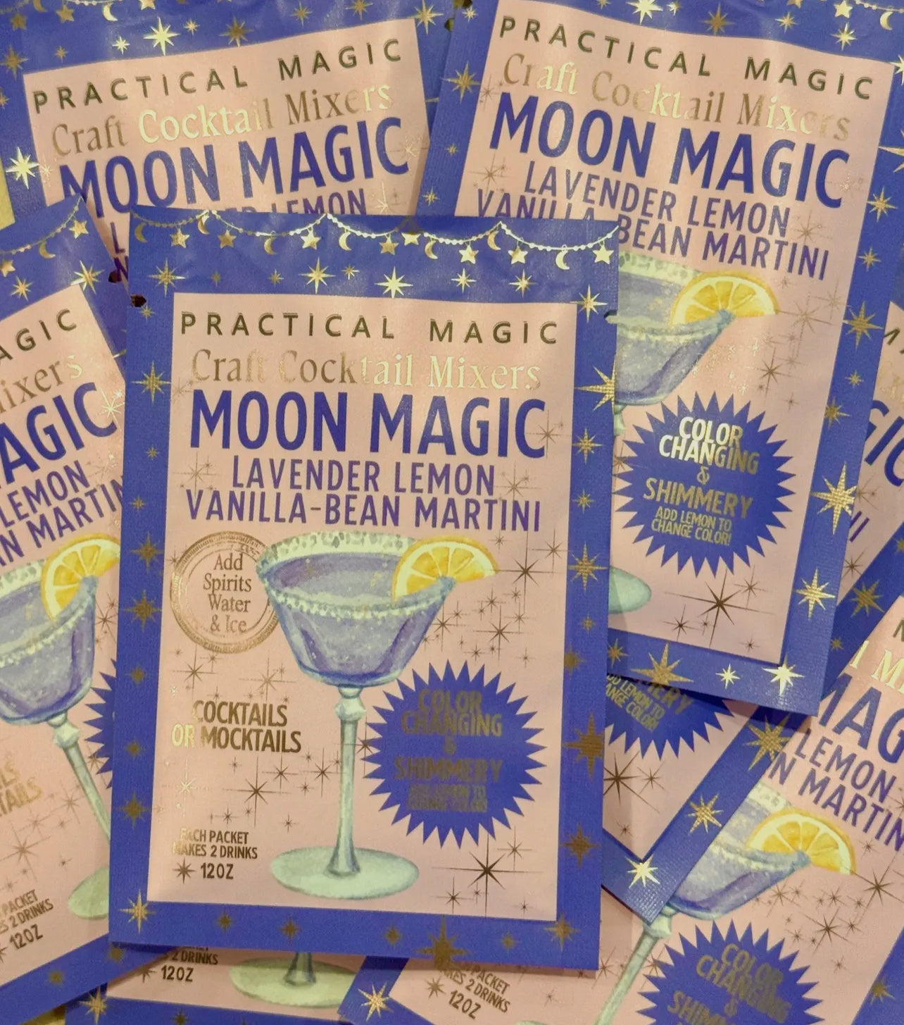 Moon Magic cocktail mix packages with star and moon designs on a blue background