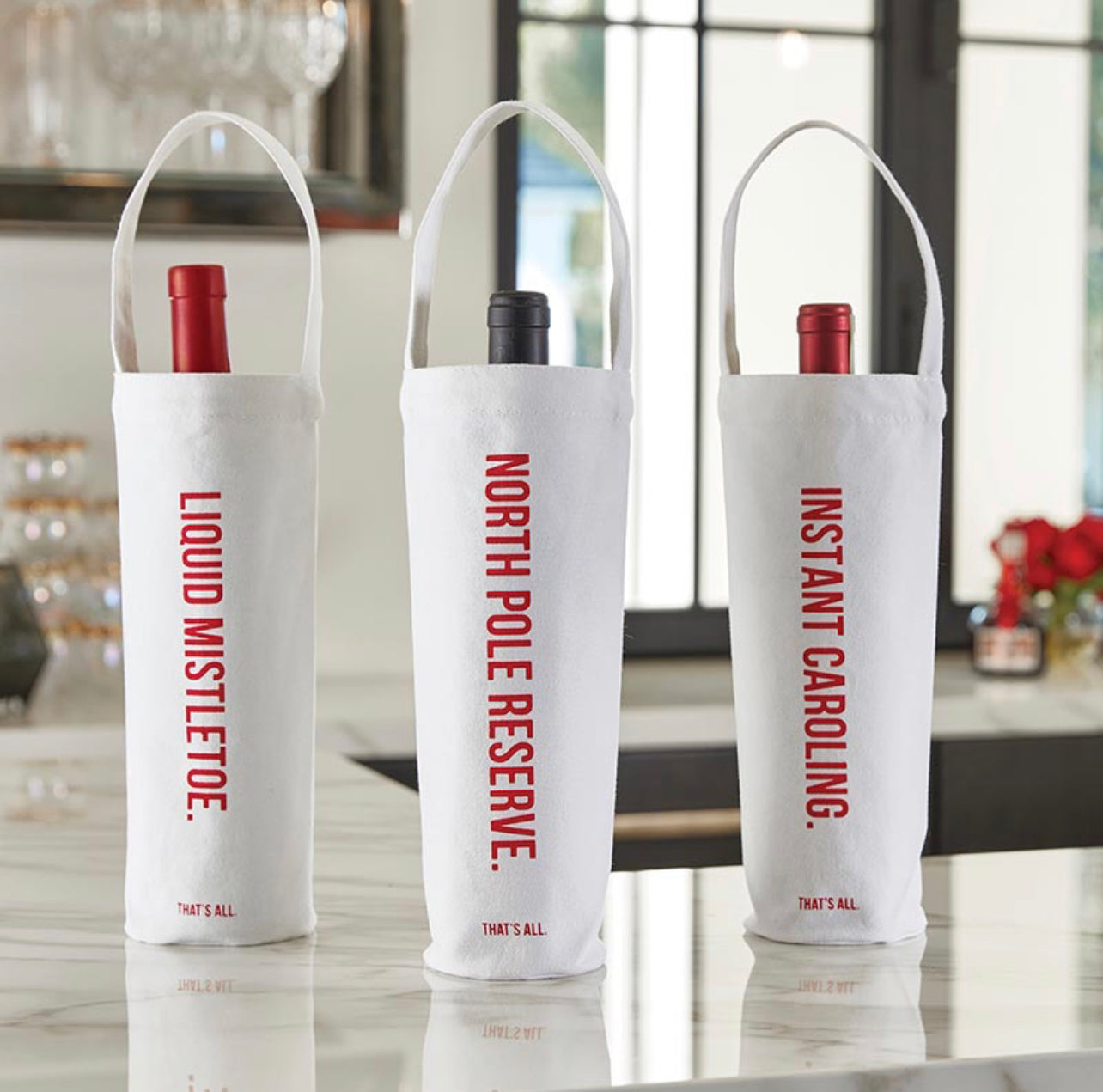 display of white canvas wine bags with festive red script