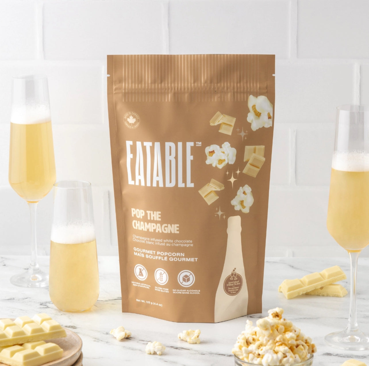 Eatable popcorn packaging with champagne-themed design on a white background