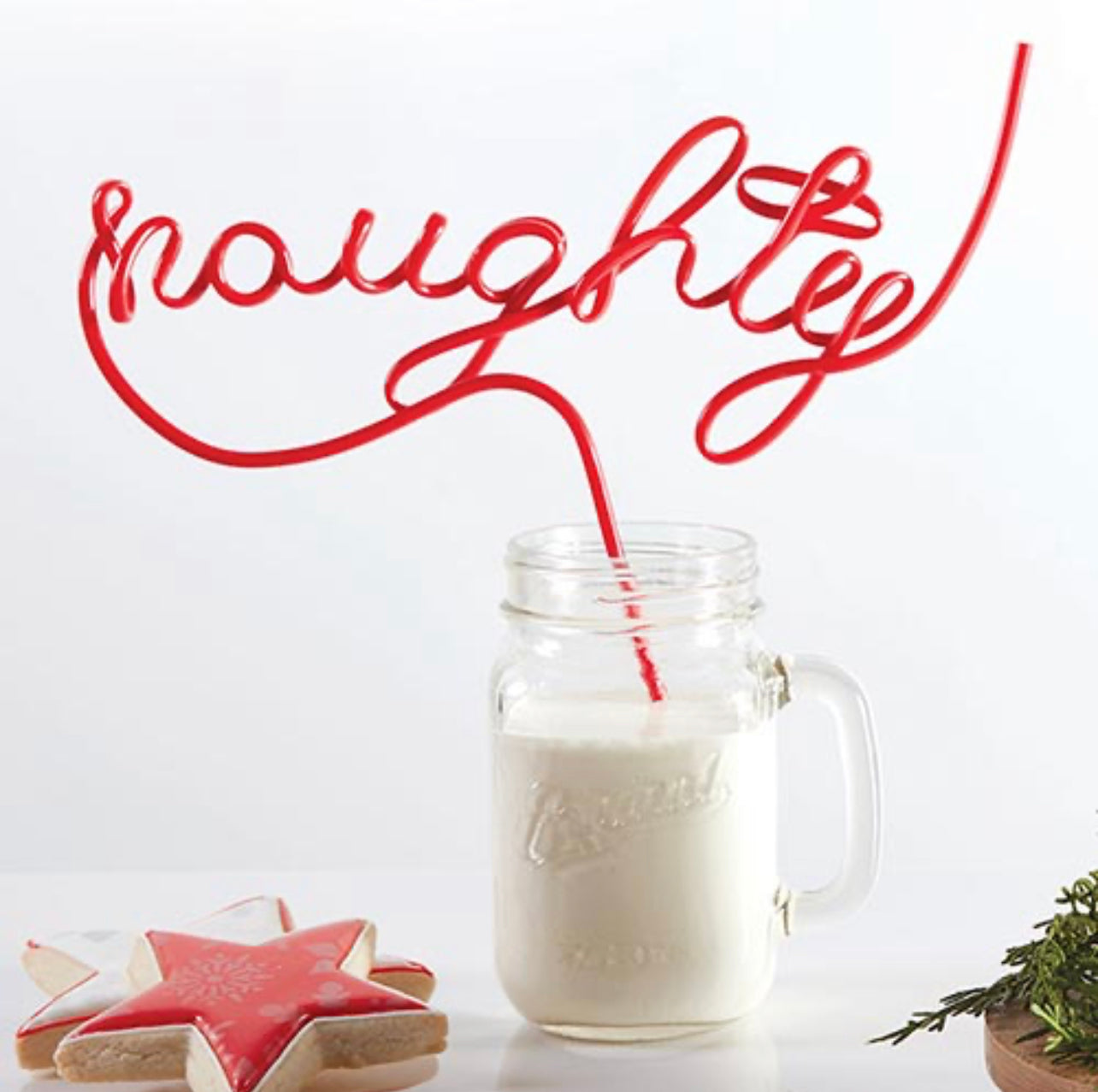 example of the christmas word straw "naughty" being used in a glass of milk with christmas cookies