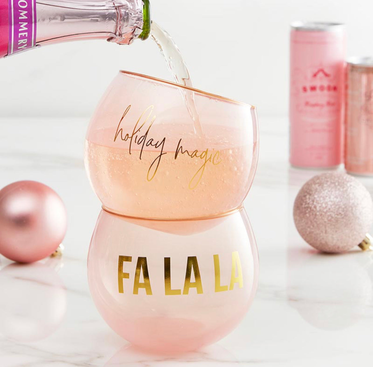 display of a set of blush colored holiday cocktail glasses with sparkling wine being poured in them