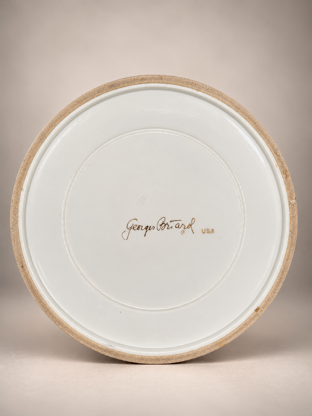 Underside of vintage beige ice bucket showing original Georges Briard USA signature on white base.
