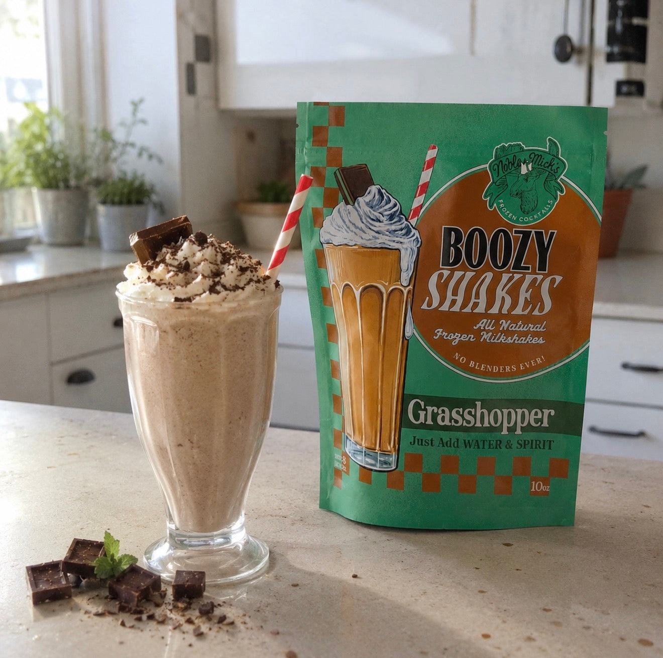 Prepared creamy Grasshopper boozy milkshake with whipped cream and chocolate beside Noble Mick’s Grasshopper Boozy Shakes mix.