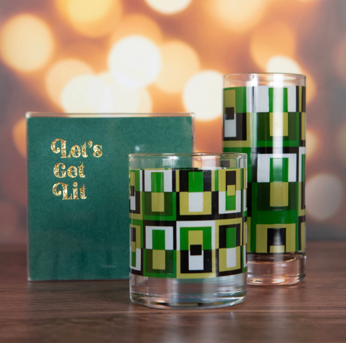 Green geometric rocks and highball glasses displayed with retro cocktail napkins in a mid century inspired setting