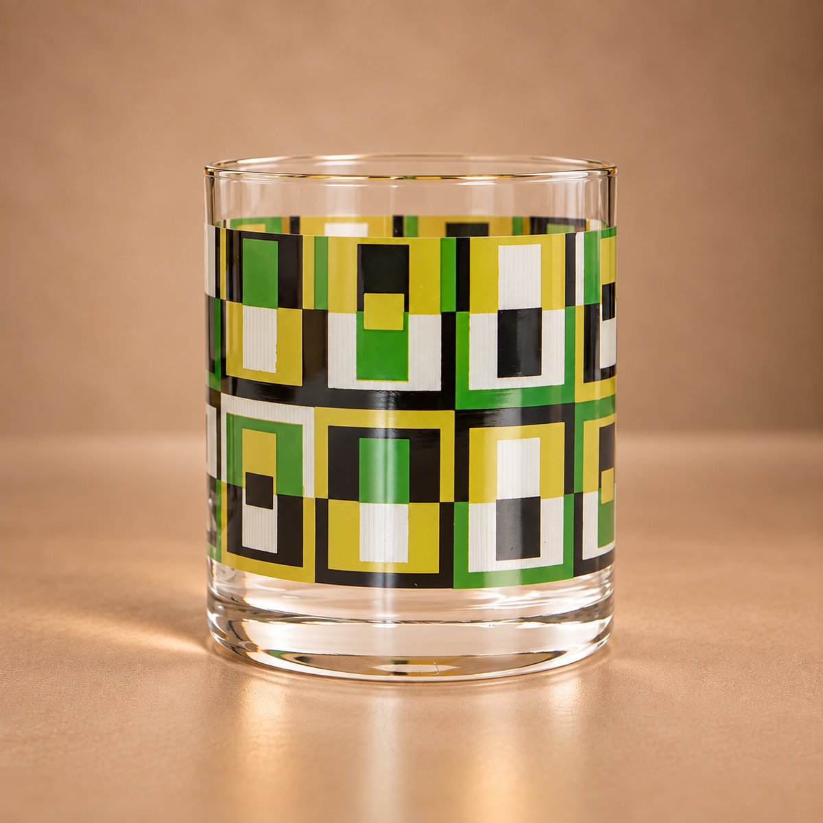 Clear 10 oz whiskey rocks glass featuring an avocado green, olive, black and white geometric square pattern