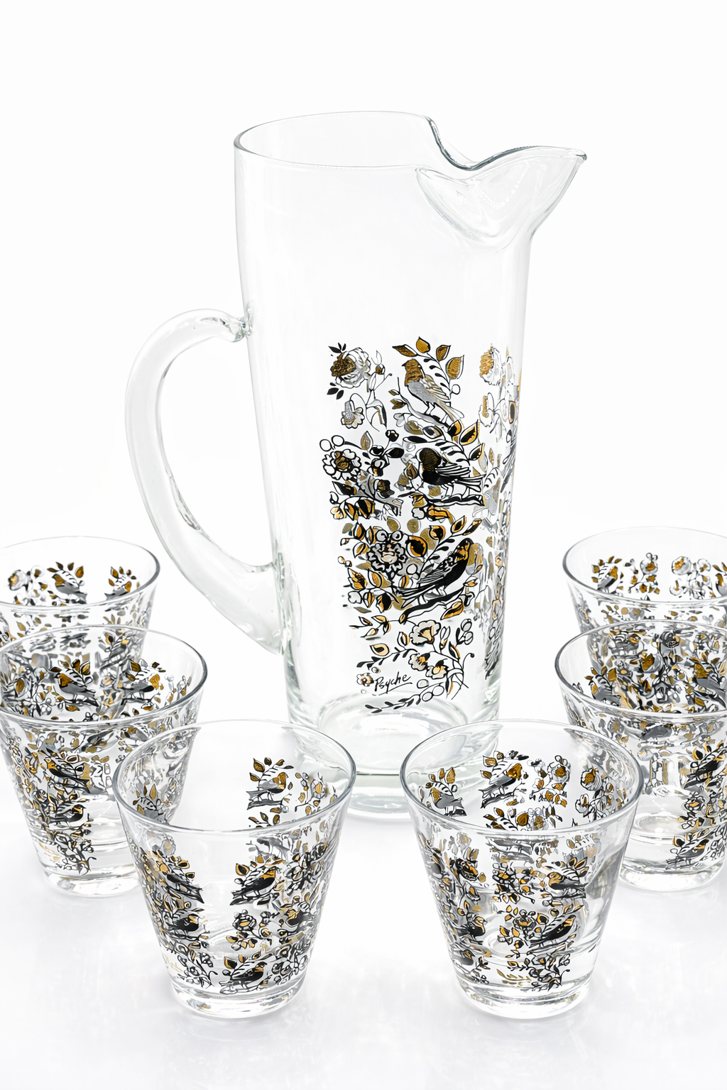 Set of glass pitcher and tumblers with floral patterns on a white background