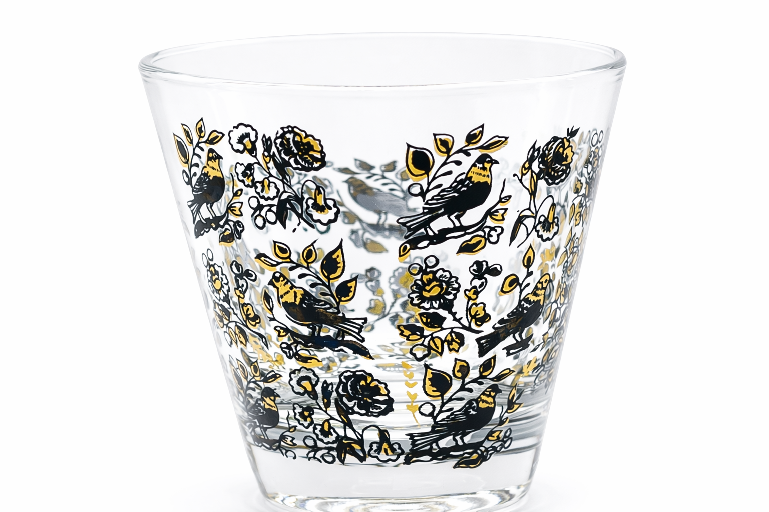 Clear glass tumbler with black and gold floral and bird pattern on a white background