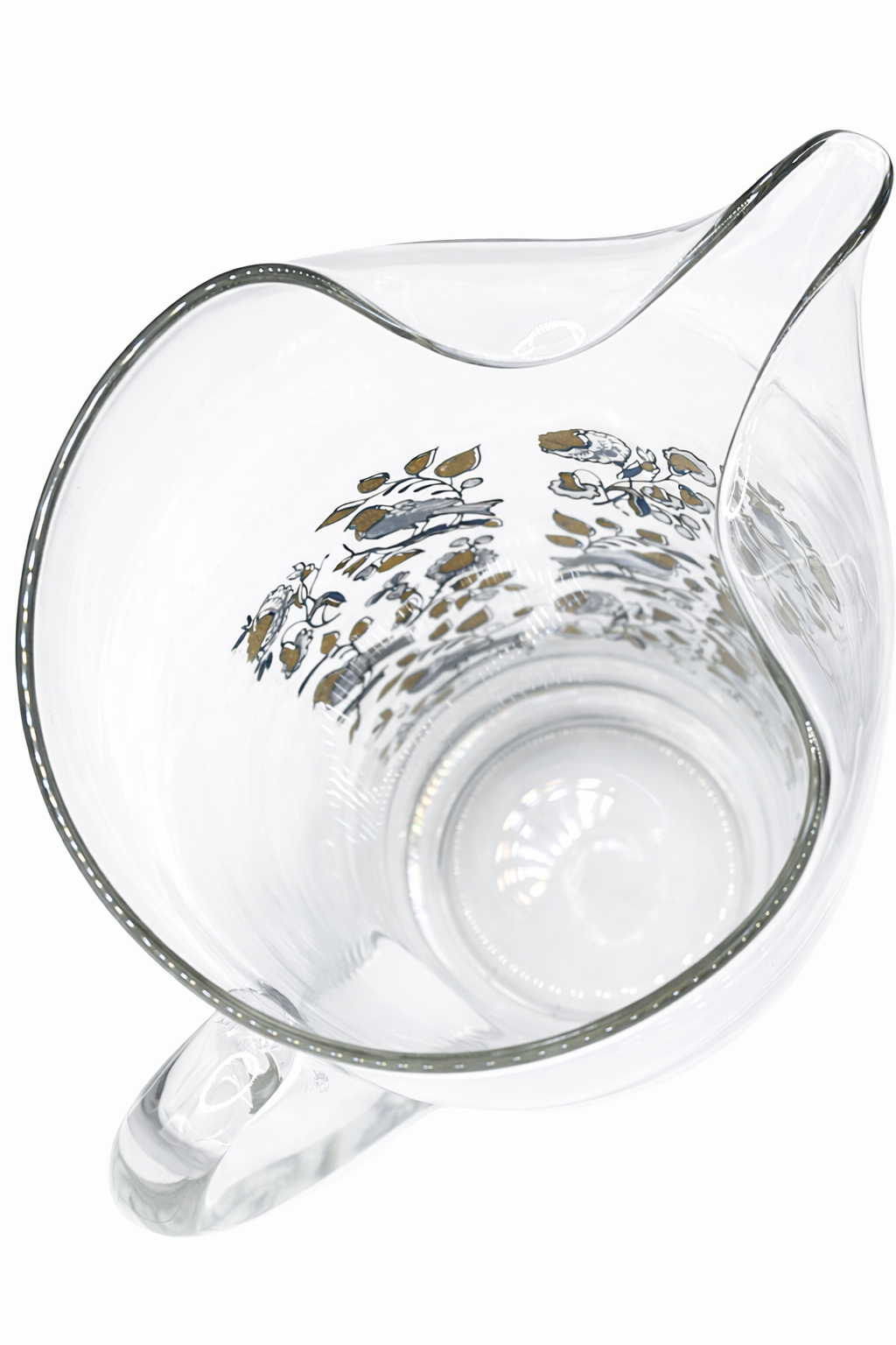 Clear glass pitcher with floral design on a white background