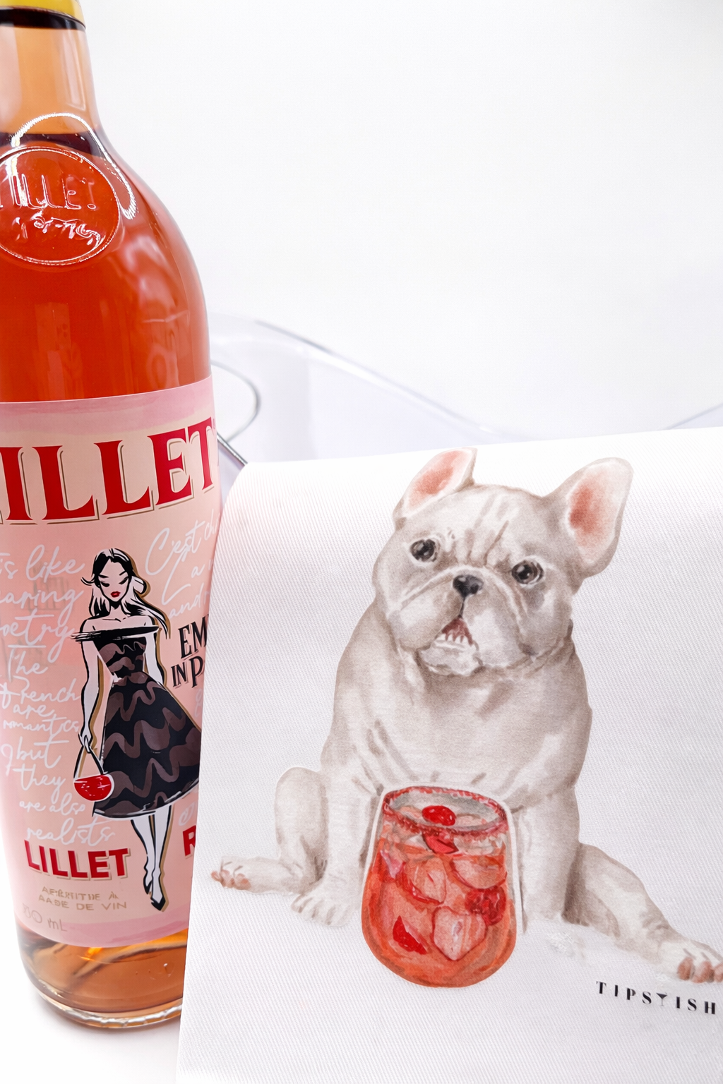 Lillet bottle with a dog tea towel holding a cocktail on a white background