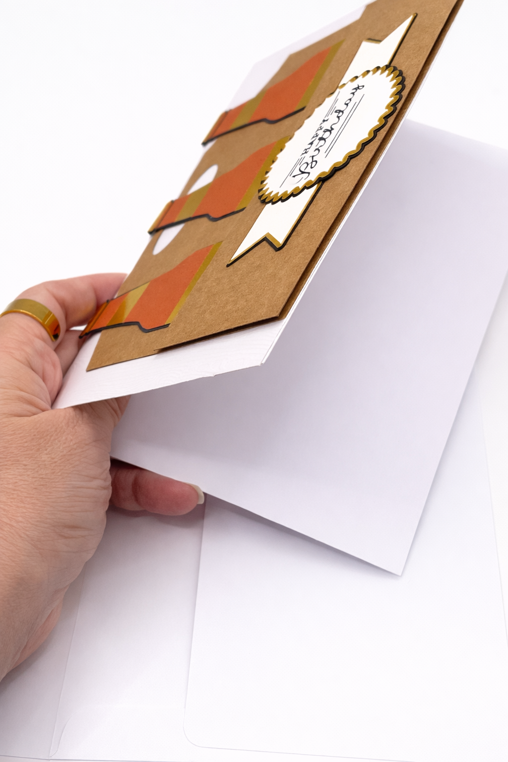 Hand holding a brown card that is blank inside on a white background
