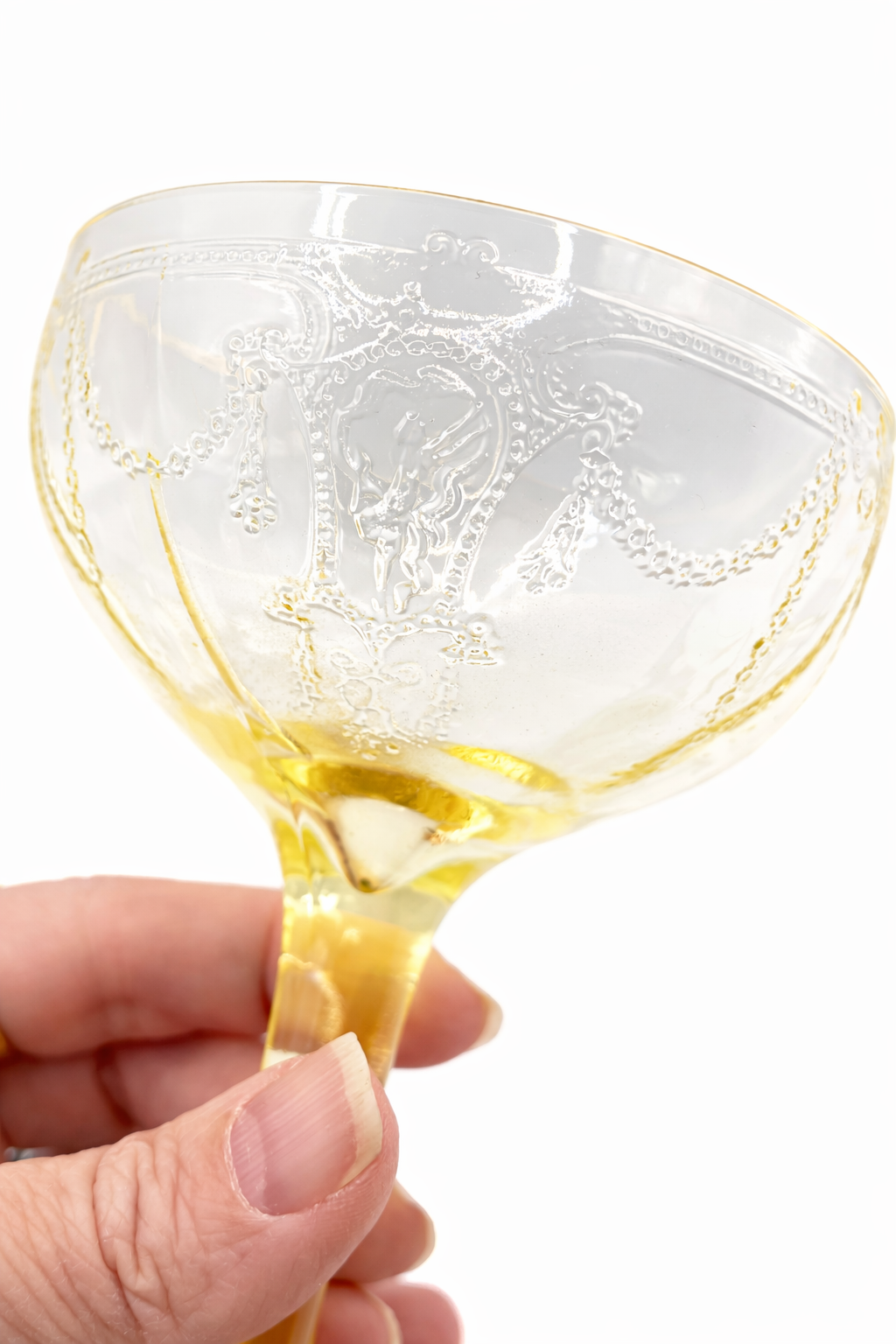 Close-up of etched floral garland and beaded detail on Anchor Hocking Cameo canary yellow Depression glass coupe
