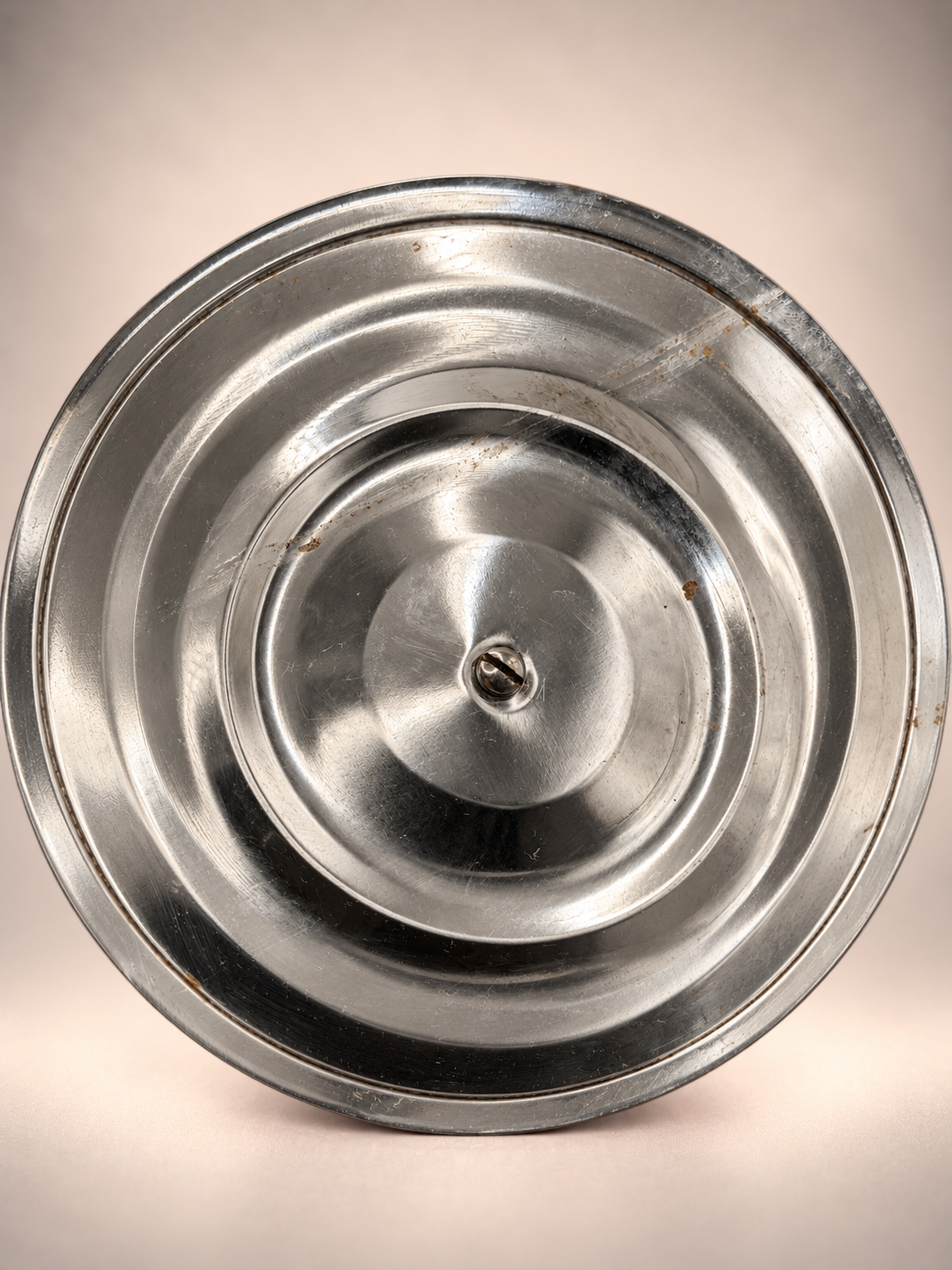 Underside of vintage metal ice bucket lid showing scratches, discoloration, and age-related surface marks.