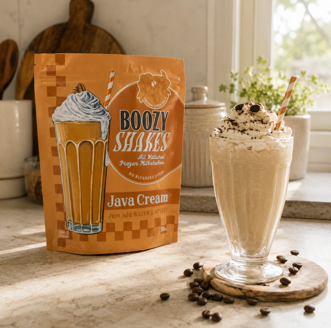 Creamy Java Cream frozen coffee cocktail topped with whipped cream and coffee beans beside Noble Mick’s Boozy Shakes mix.