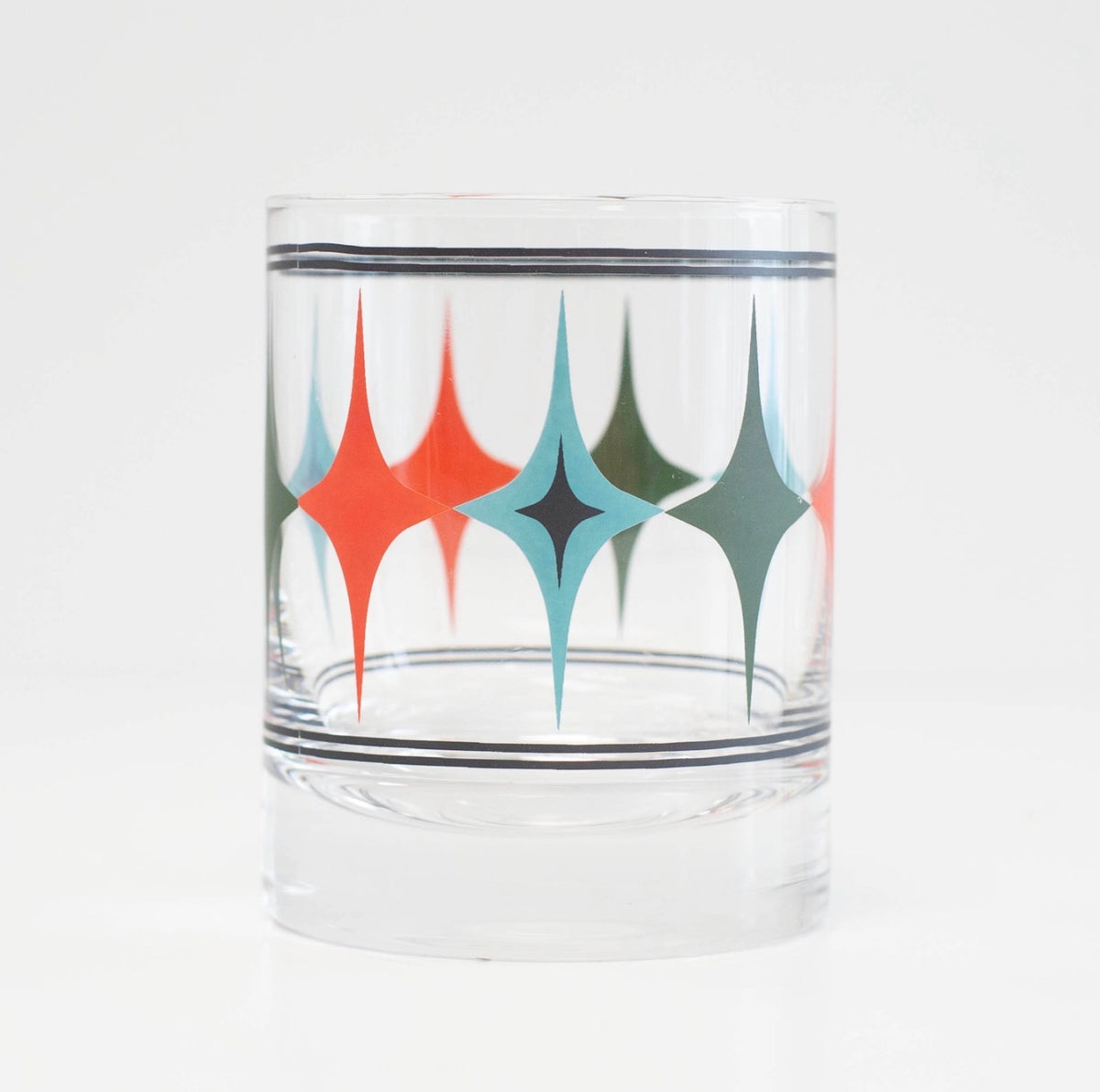 Clear 10 oz whiskey rocks glass with coral, turquoise, green and black mid century modern starlight diamond pattern