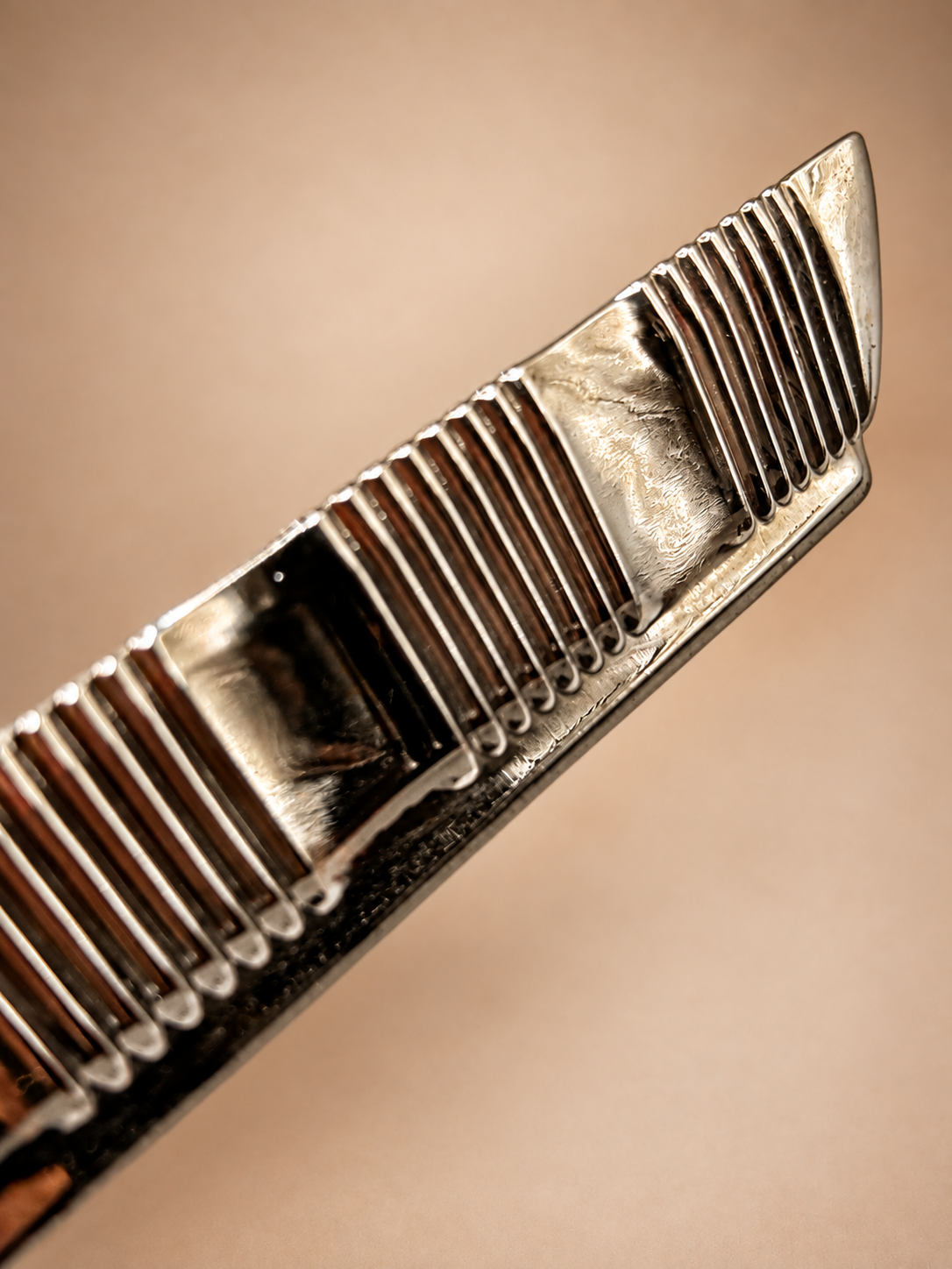 Close-up side view showing ribbed silver-tone edge and vintage surface wear on divided relish dish.