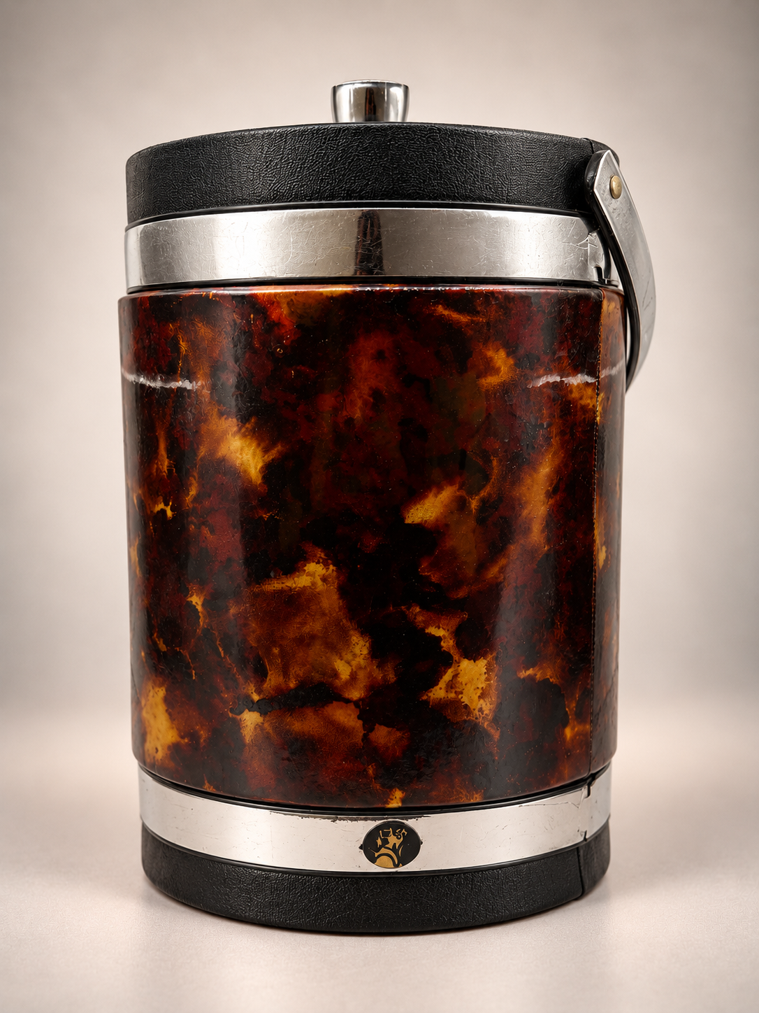 Vintage Elmar Mfg. ice bucket featuring amber-brown faux tortoiseshell exterior, silver-tone bands, black trim, and decorative emblem.