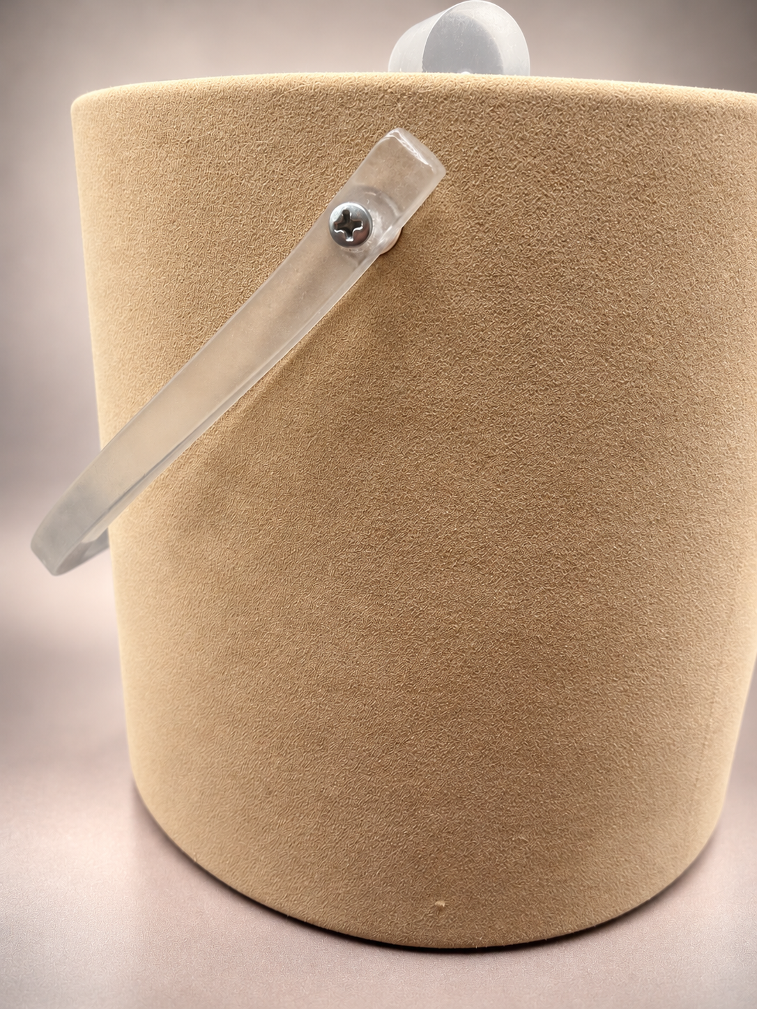 Close-up of beige textured exterior and frosted acrylic-style handle showing surface marks and minor vintage wear.