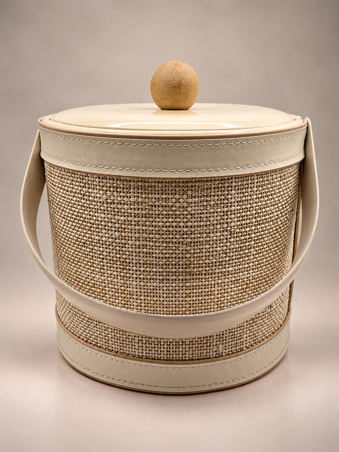 Vintage Georges Briard ice bucket with beige woven-look exterior, ivory trim, carrying handle and wooden ball lid knob.