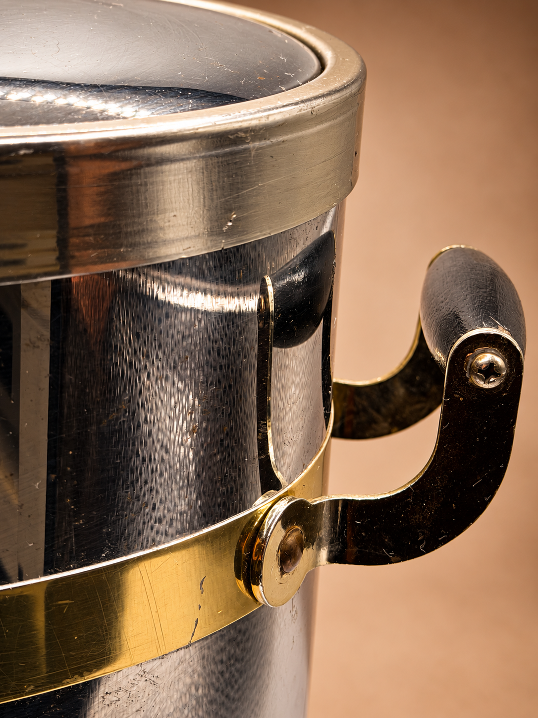 Close-up of vintage Kraftware ice bucket showing dark handle, gold-tone hardware and typical surface wear.