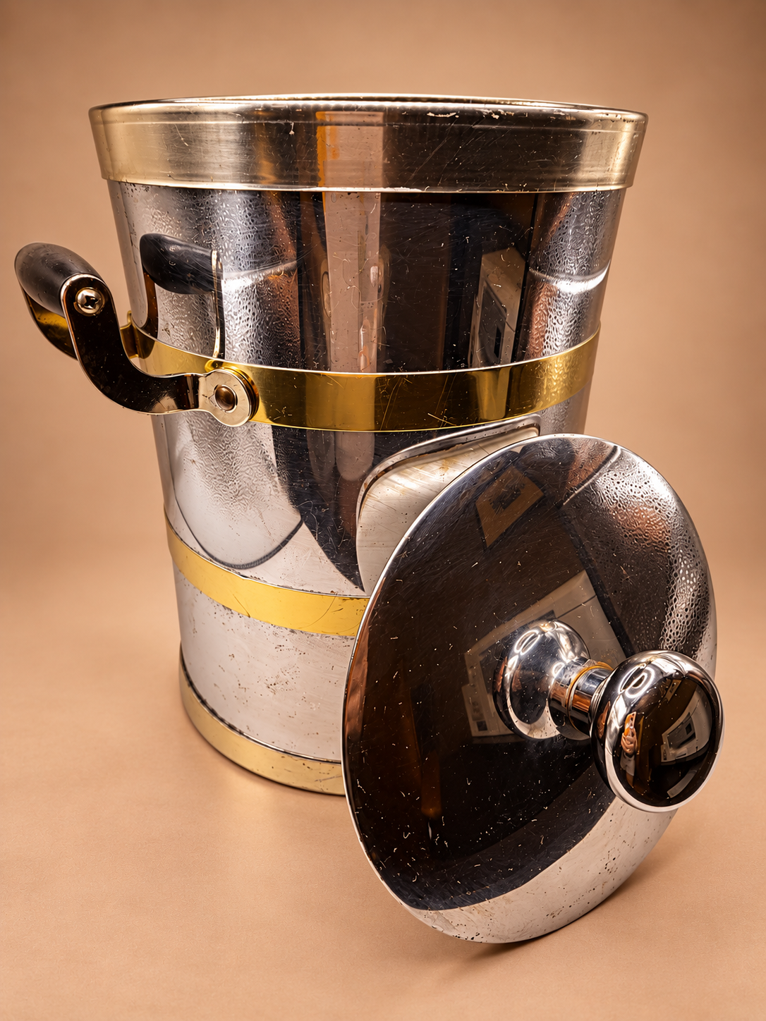Vintage Kraftware chrome and gold-tone ice bucket with removable reflective lid showing age-appropriate surface wear.