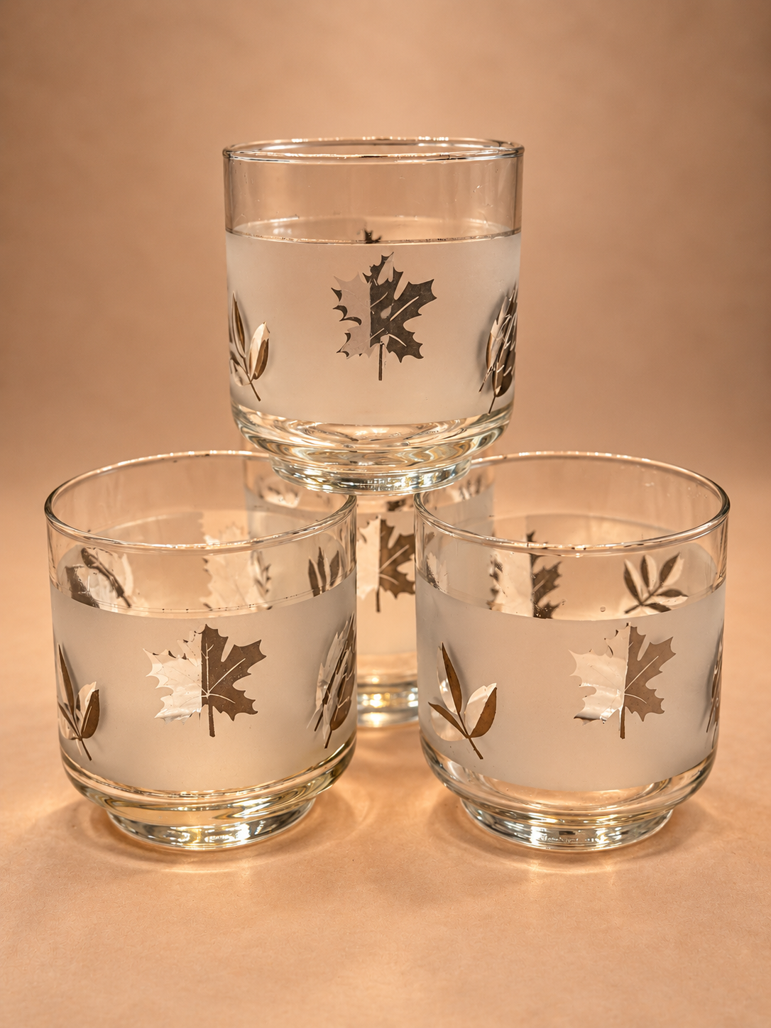 Set of four vintage Libbey Silver Leaf rocks glasses with frosted bands, metallic silver foliage and clear glass bases.