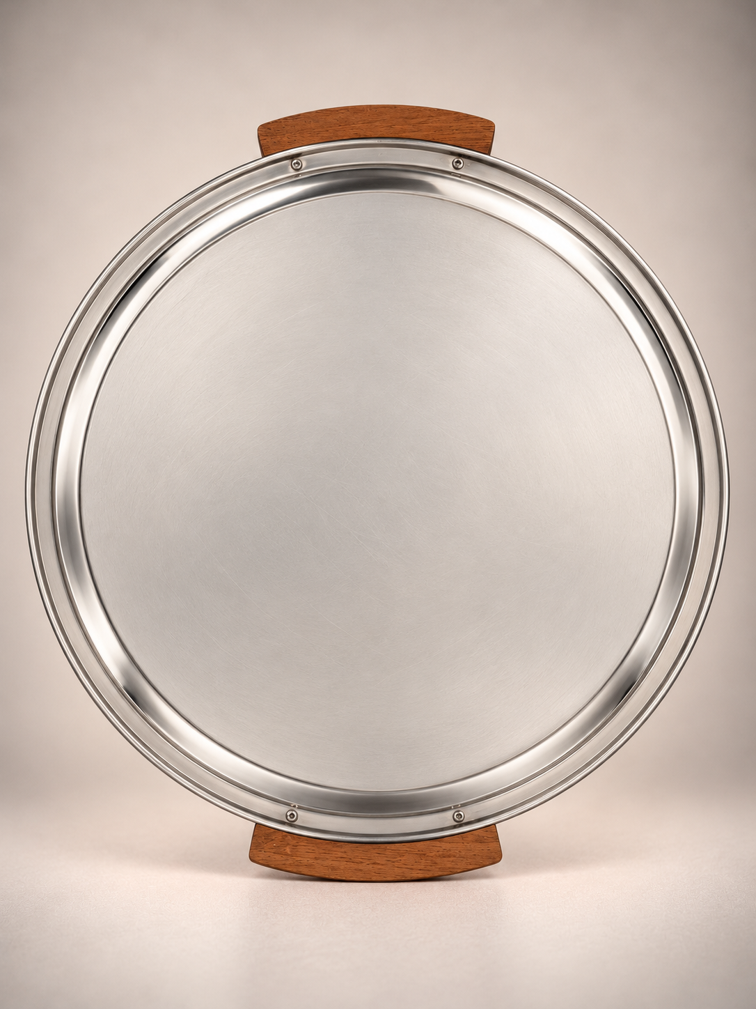 Underside of vintage round metal serving tray showing silver-tone finish, wooden handles, and metal fasteners.