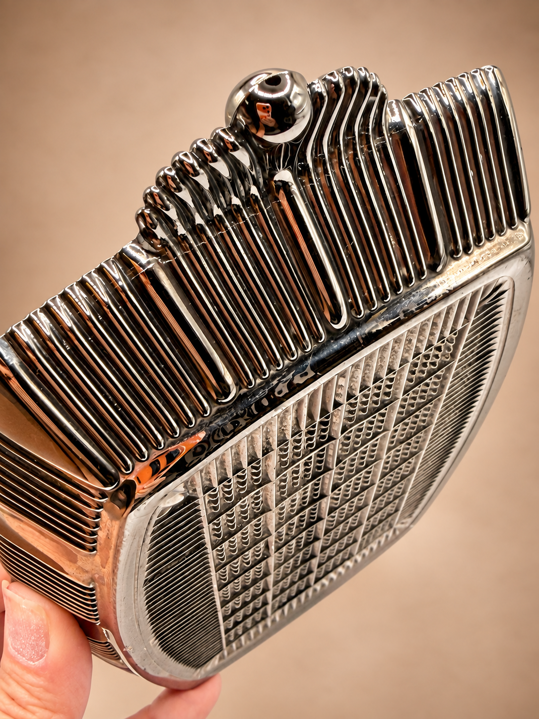 Detailed underside view of vintage divided serving dish showing reflective ribbed handle and geometric textured glass.