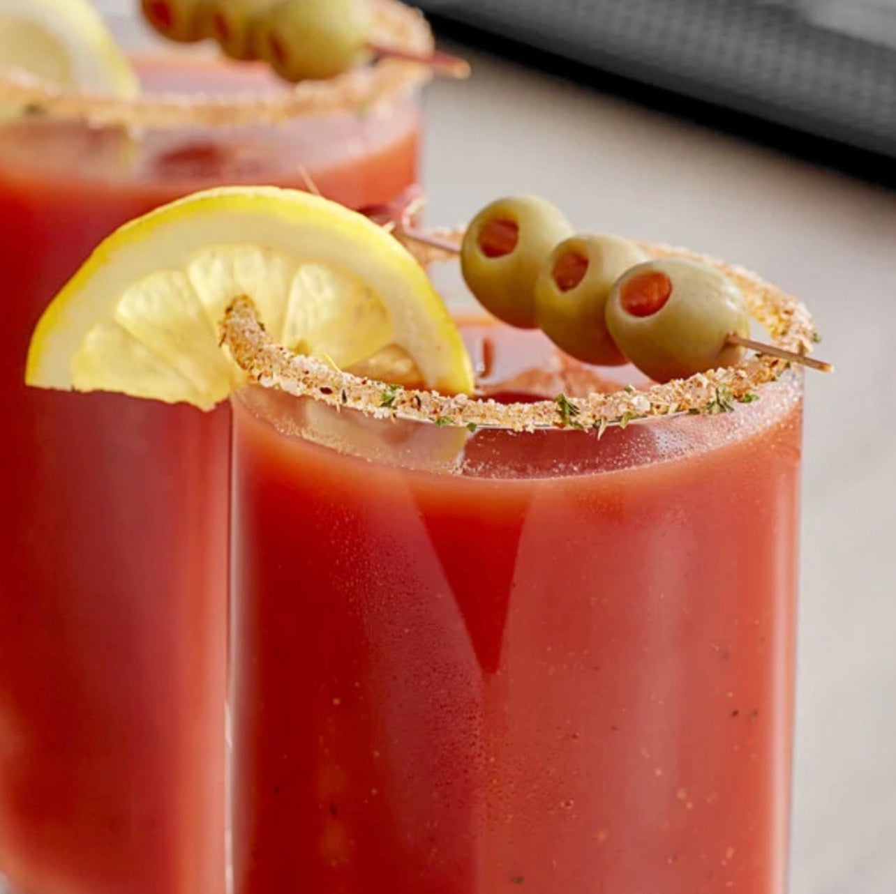 Brunch Bloody Mary cocktail with lemon wedge and olive skewer featuring savory salt rim.