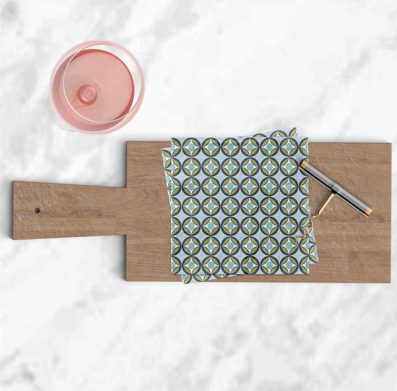 Blue raindrop circle cocktail napkins styled on wooden serving board with corkscrew and rosé.