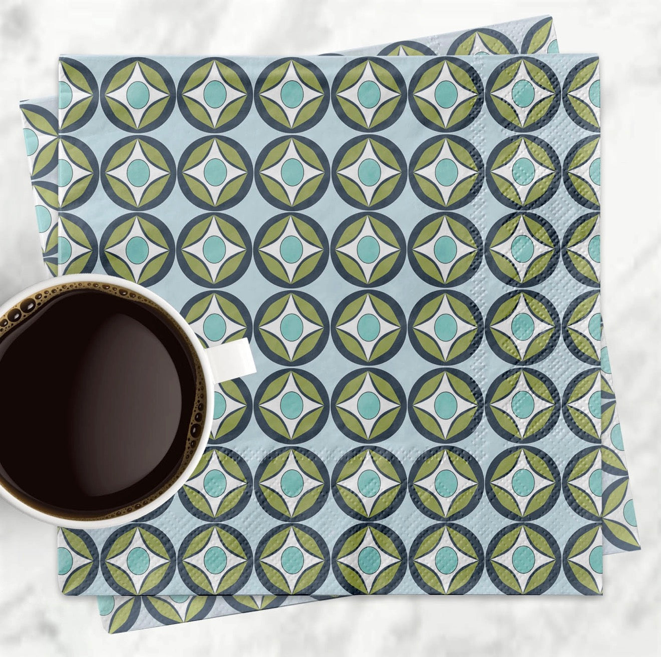 Patterned napkin with a cup of coffee on a white surface