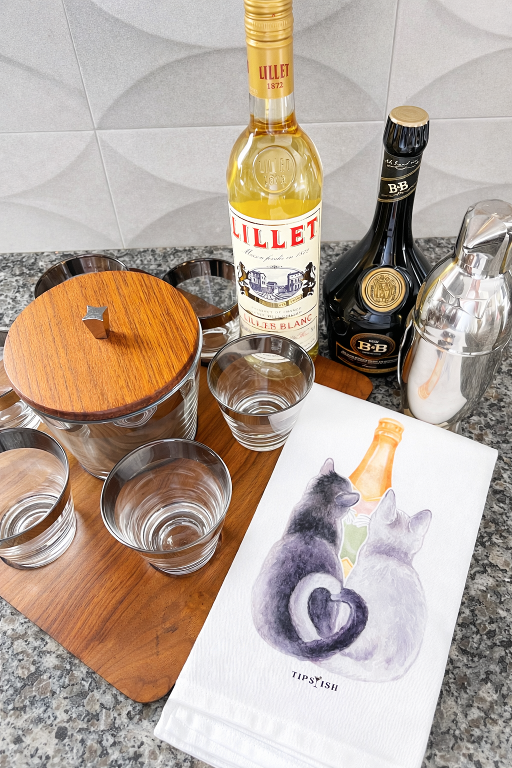 Cats and champagne kitchen towel styled with cocktail glasses and barware
