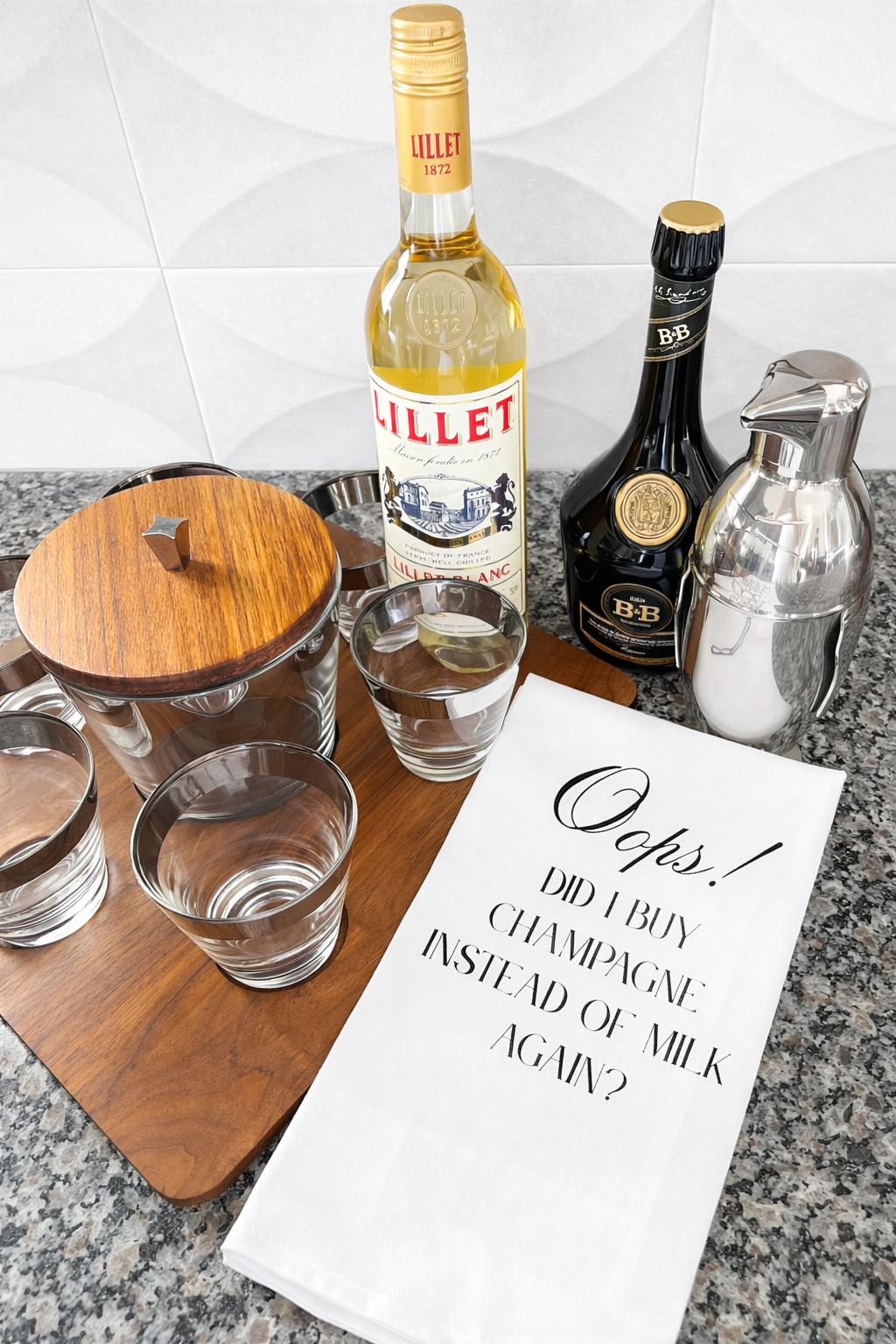 Champagne themed kitchen towel styled with barware and cocktail glasses
