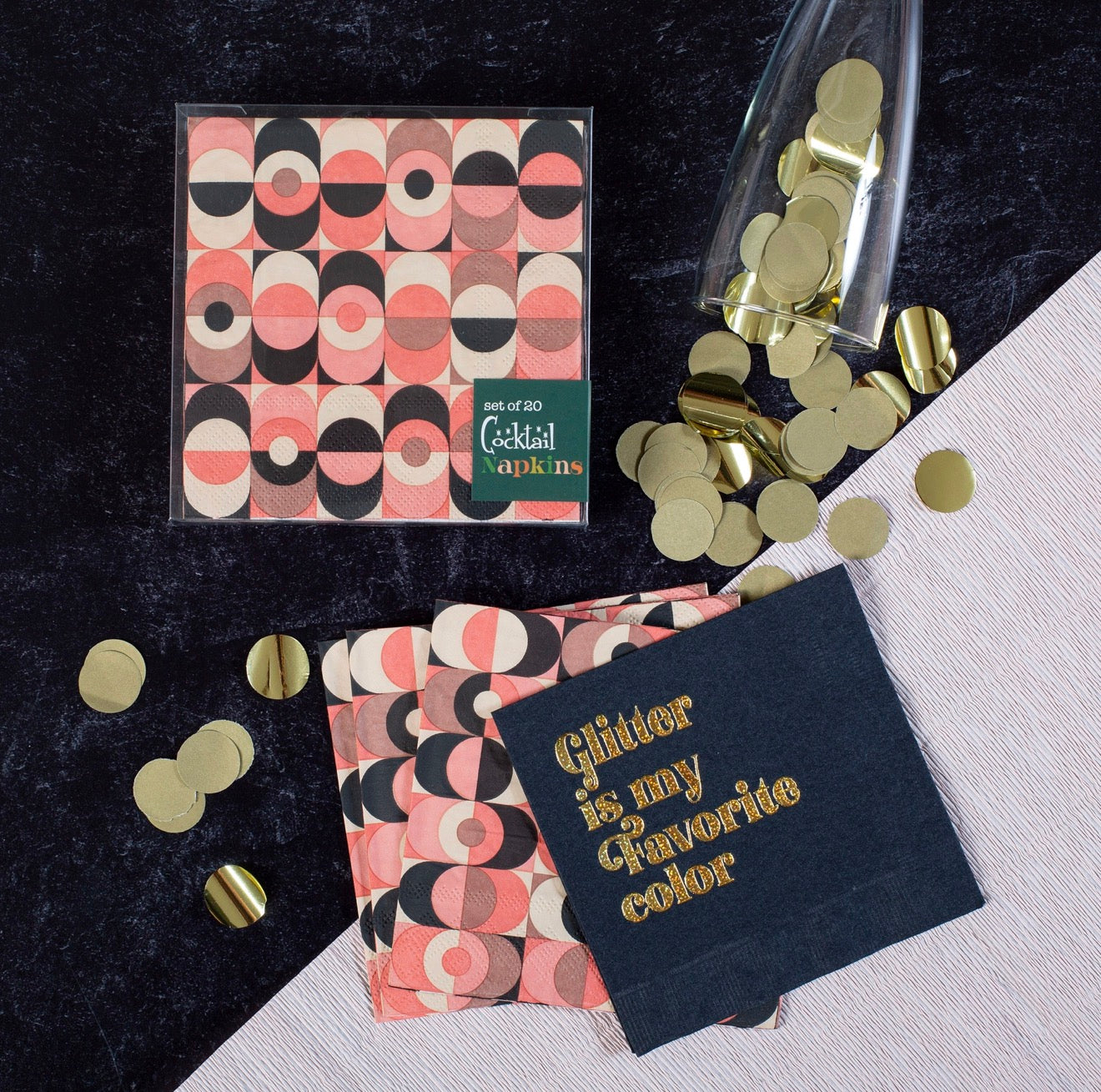 Pink geometric cocktail napkins styled with gold confetti and party accessories on velvet background