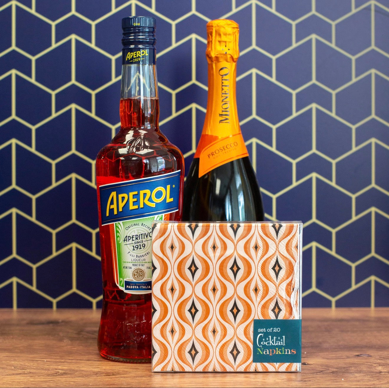 Mid century modern cocktail napkins styled with Aperol and prosecco bottles for spritz party setup