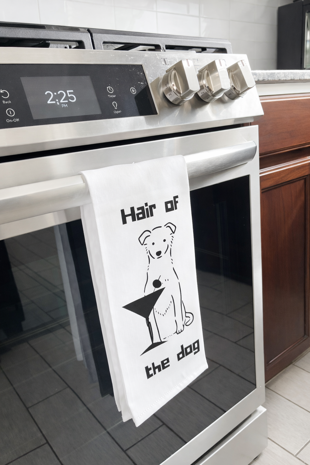 Dog themed cocktail tea towel hanging on oven handle in modern kitchen
