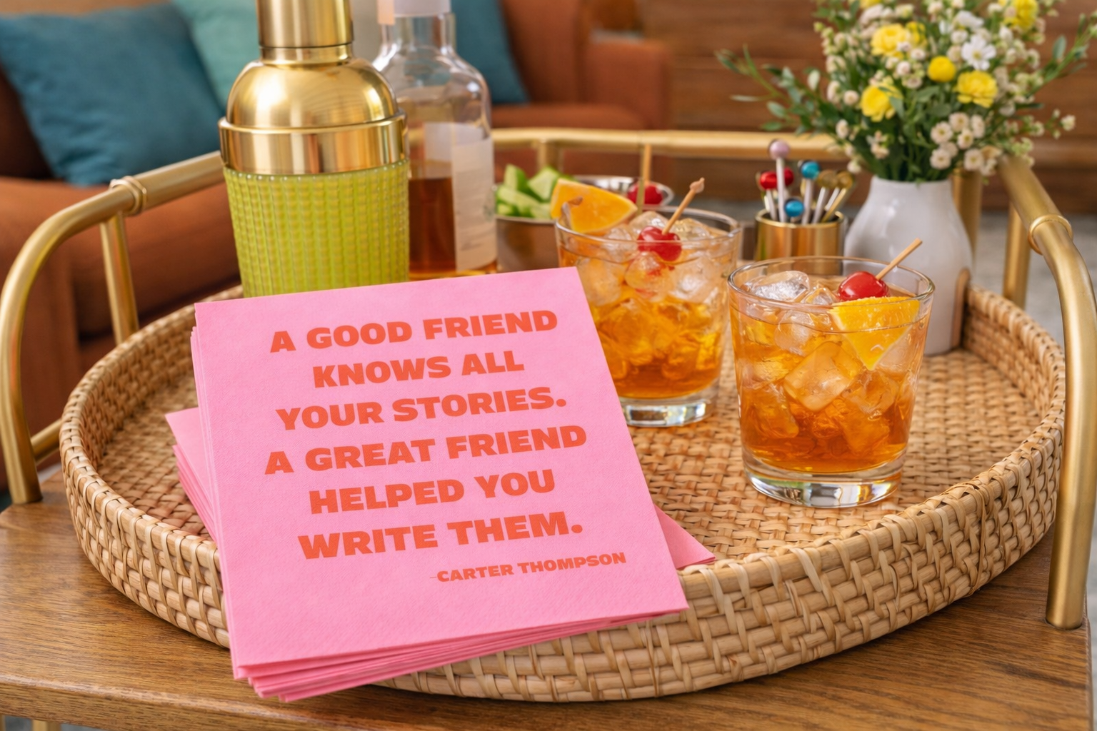 Pink funny cocktail napkins styled on wicker mid century modern bar tray with Old Fashioned cocktails and gold shaker